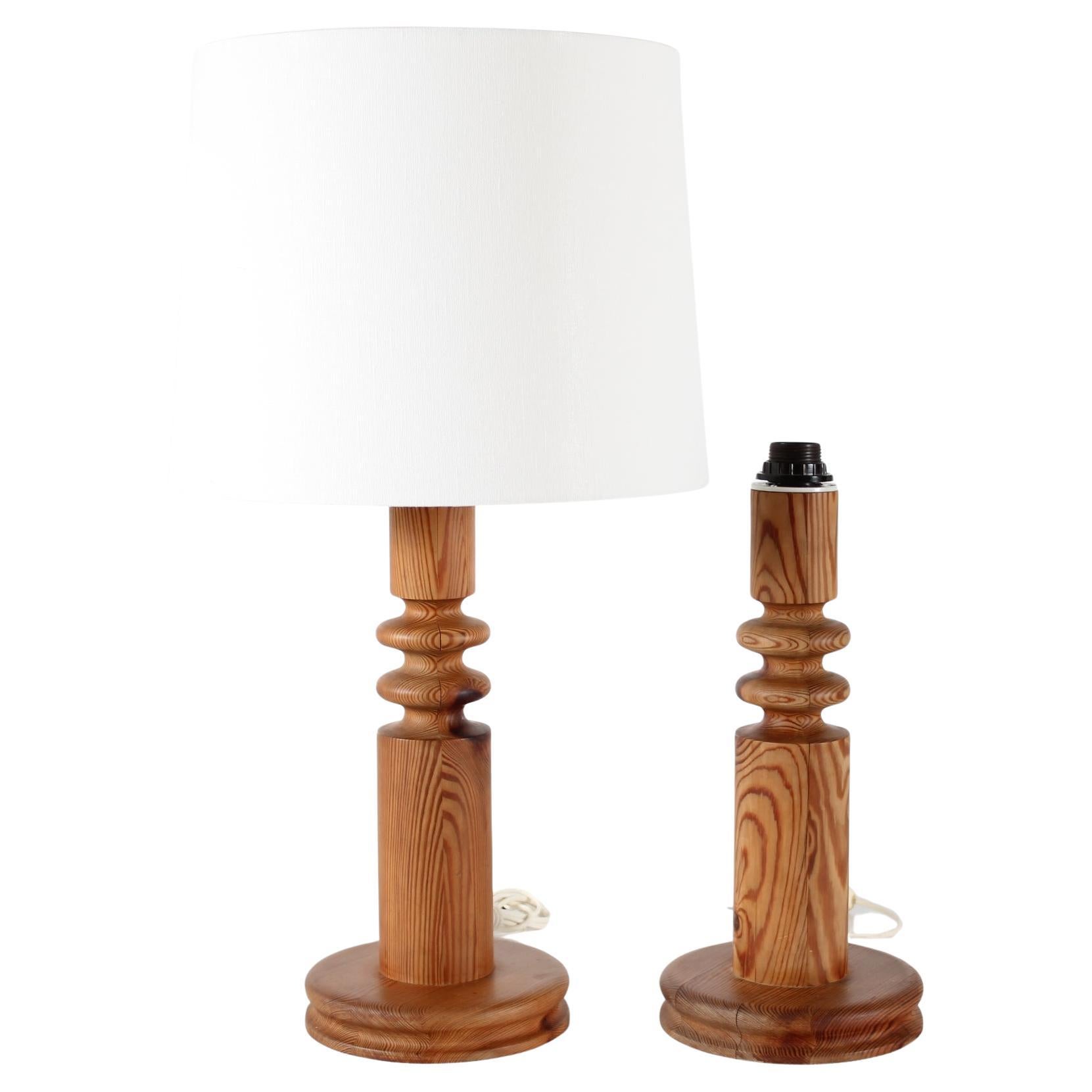 Paire de grandes lampes de table brutalistes Uno Kristiansson en pin massif tourné en Suède dans les années 1970. 

Mesures : 
Hauteur avec abat-jour 71 cm
Hauteur de la base de la lampe, douille incluse 44 cm
Hauteur de la base de la lampe partie