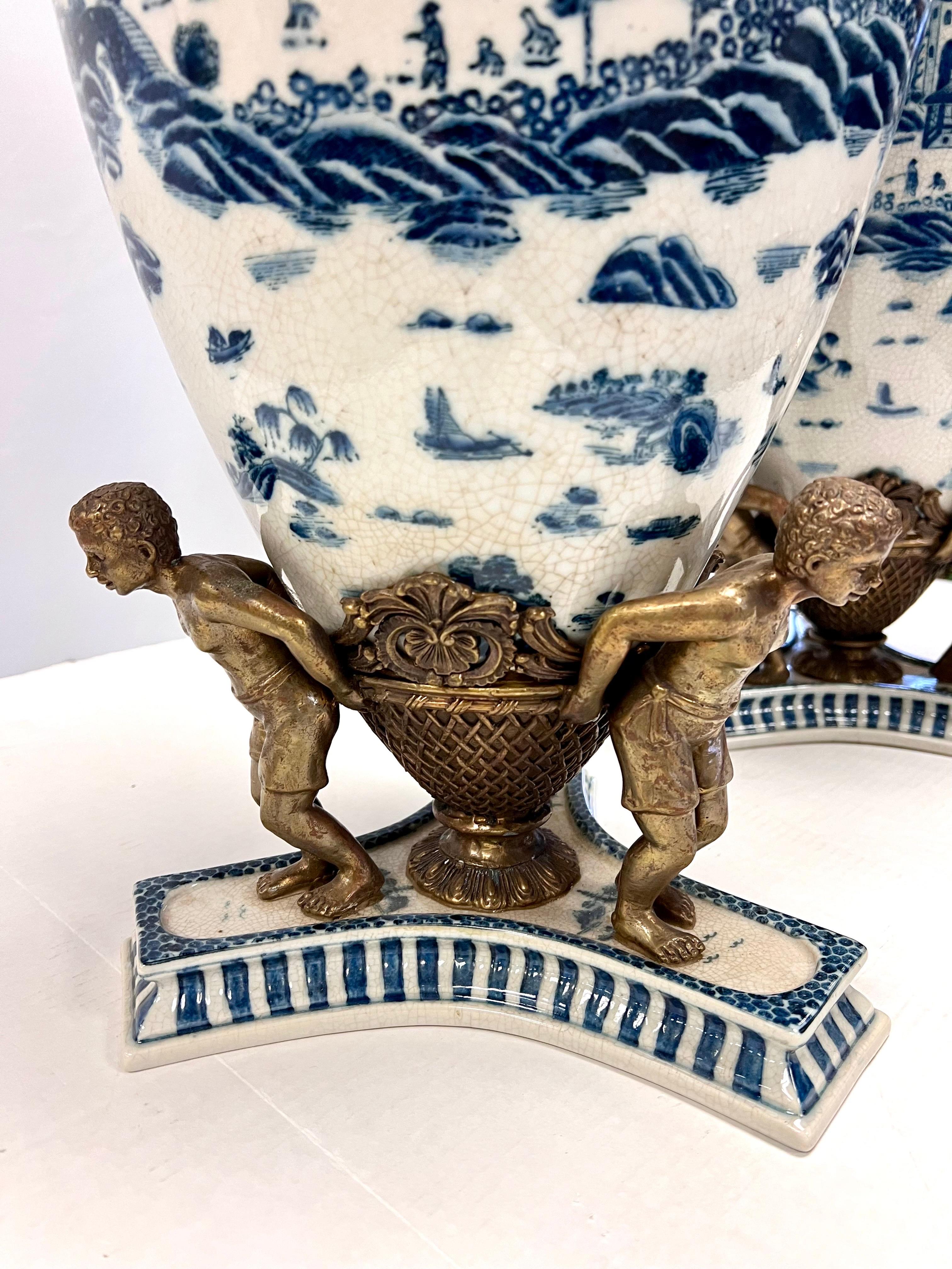 Hong Kong Pair of Tall Chinoiserie Blue and White Urns With Bronze Figural Mounts For Sale