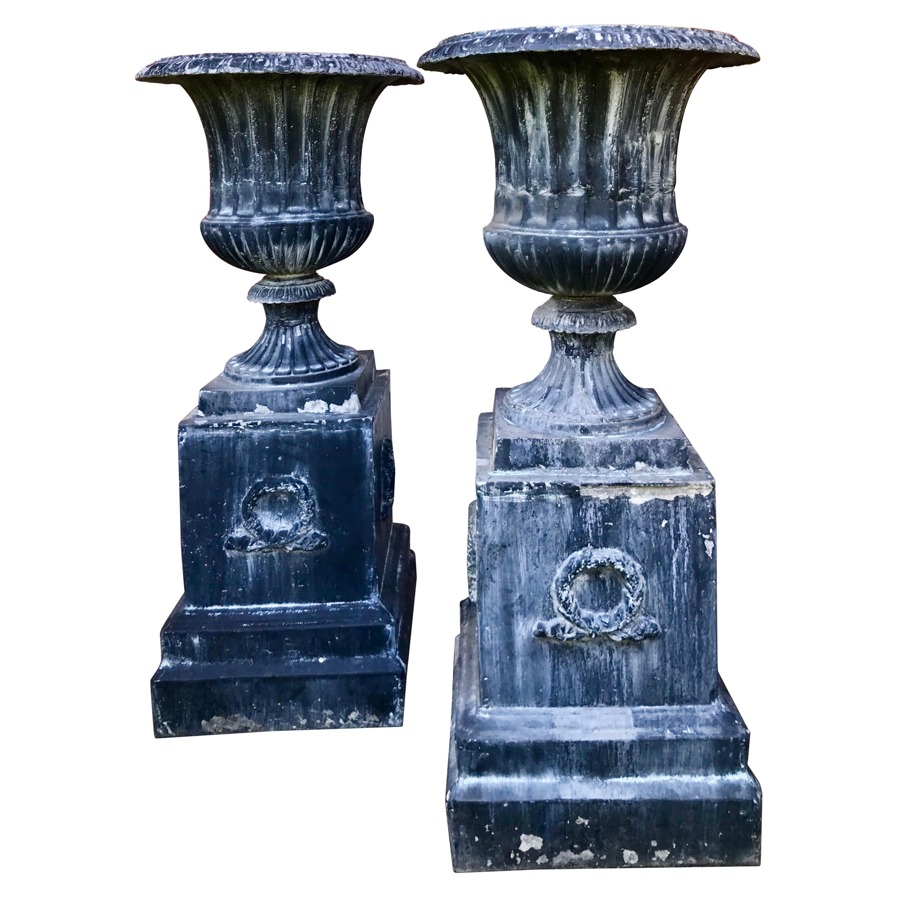 Paire de grandes urnes de jardin en métal cannelé de style classique sur pied