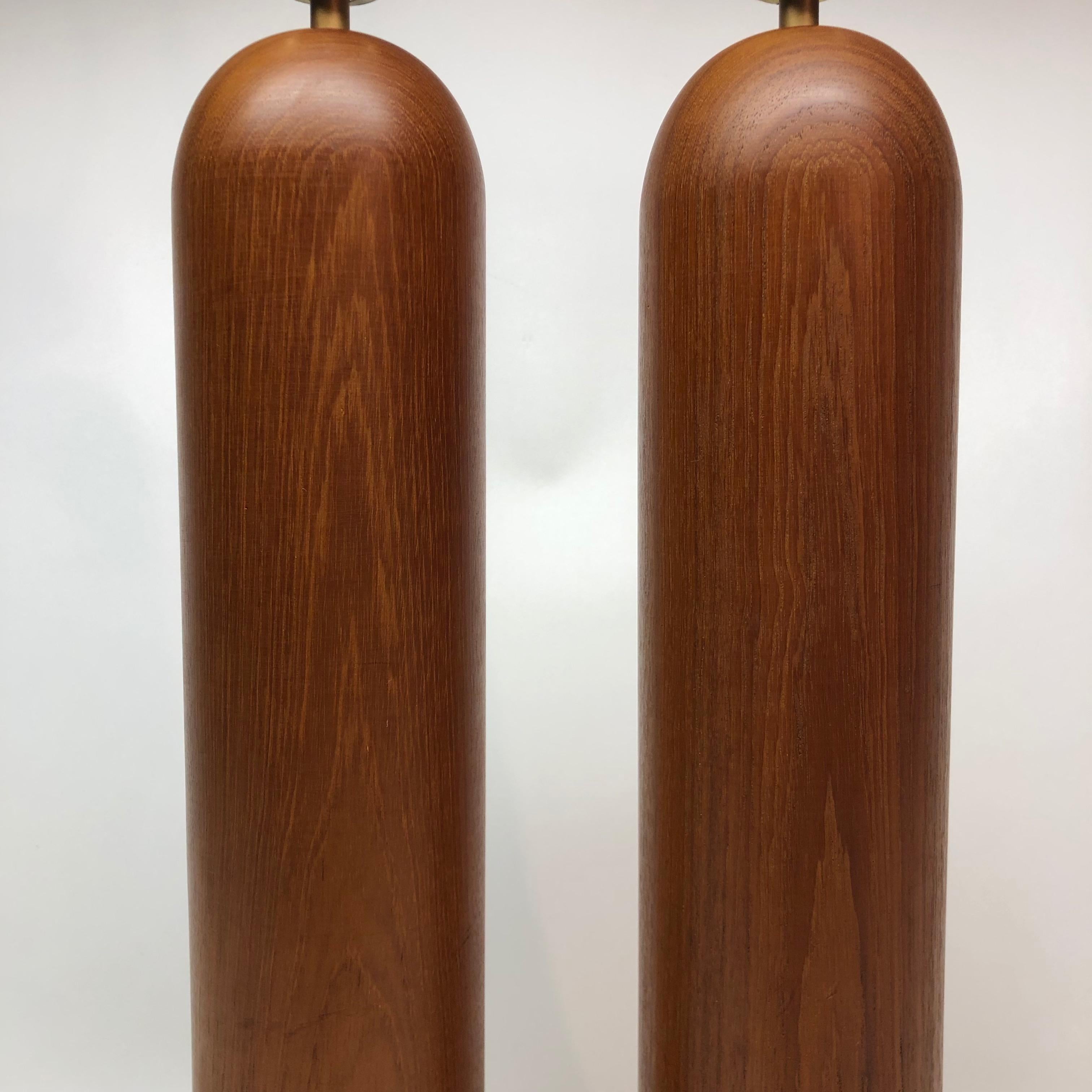 Modern pair of teak column lamps. Measures: Lamp base 20