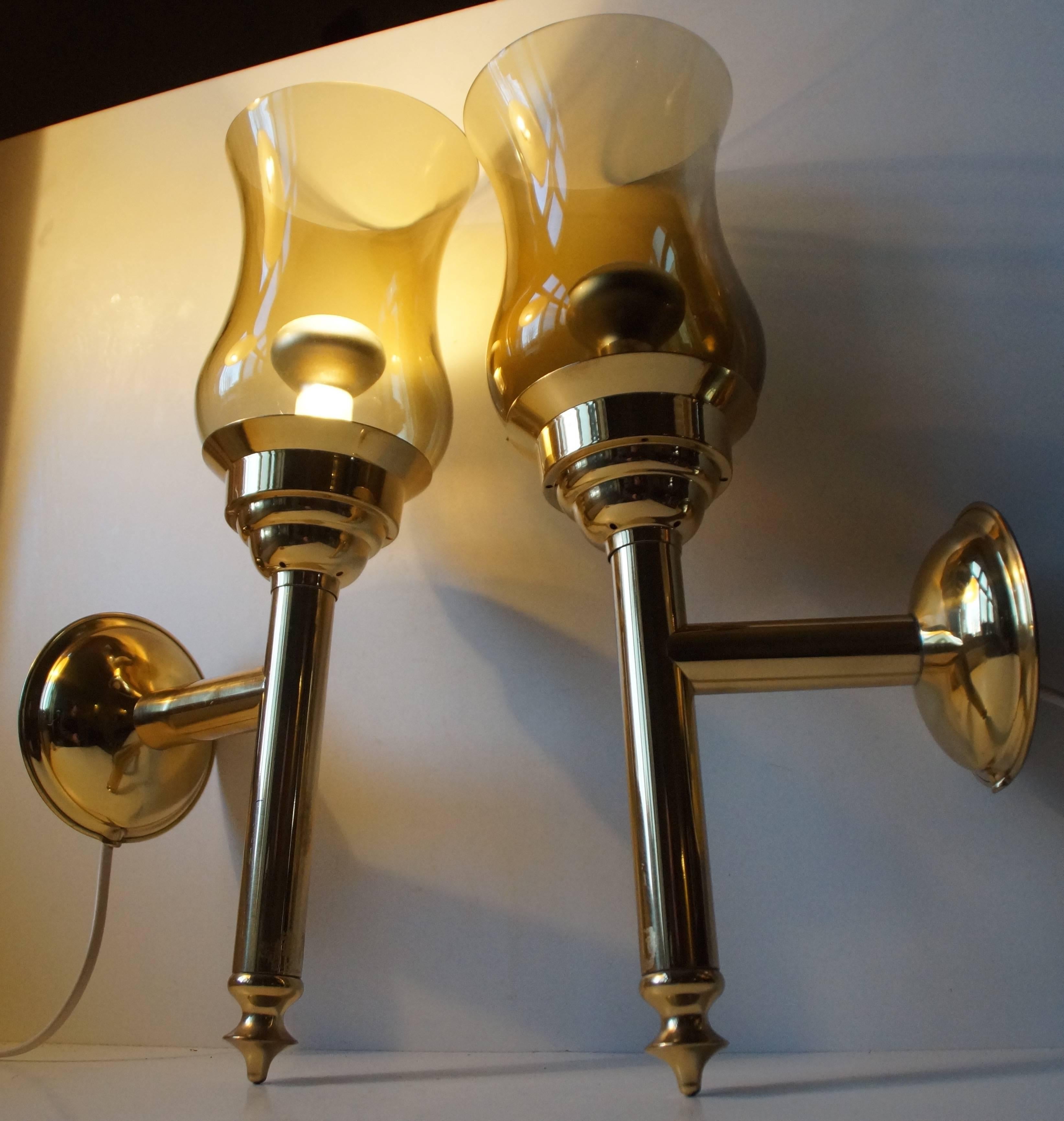 A pair of tall Danish torch-shaped wall lights made of polished brass and single layer smoke glass. Both marked with 'Danish Design' Sticker to the back of the mount. Measurements: Height 16 inches (41 cm), Depth 7 inch (18 cm). The price is for the