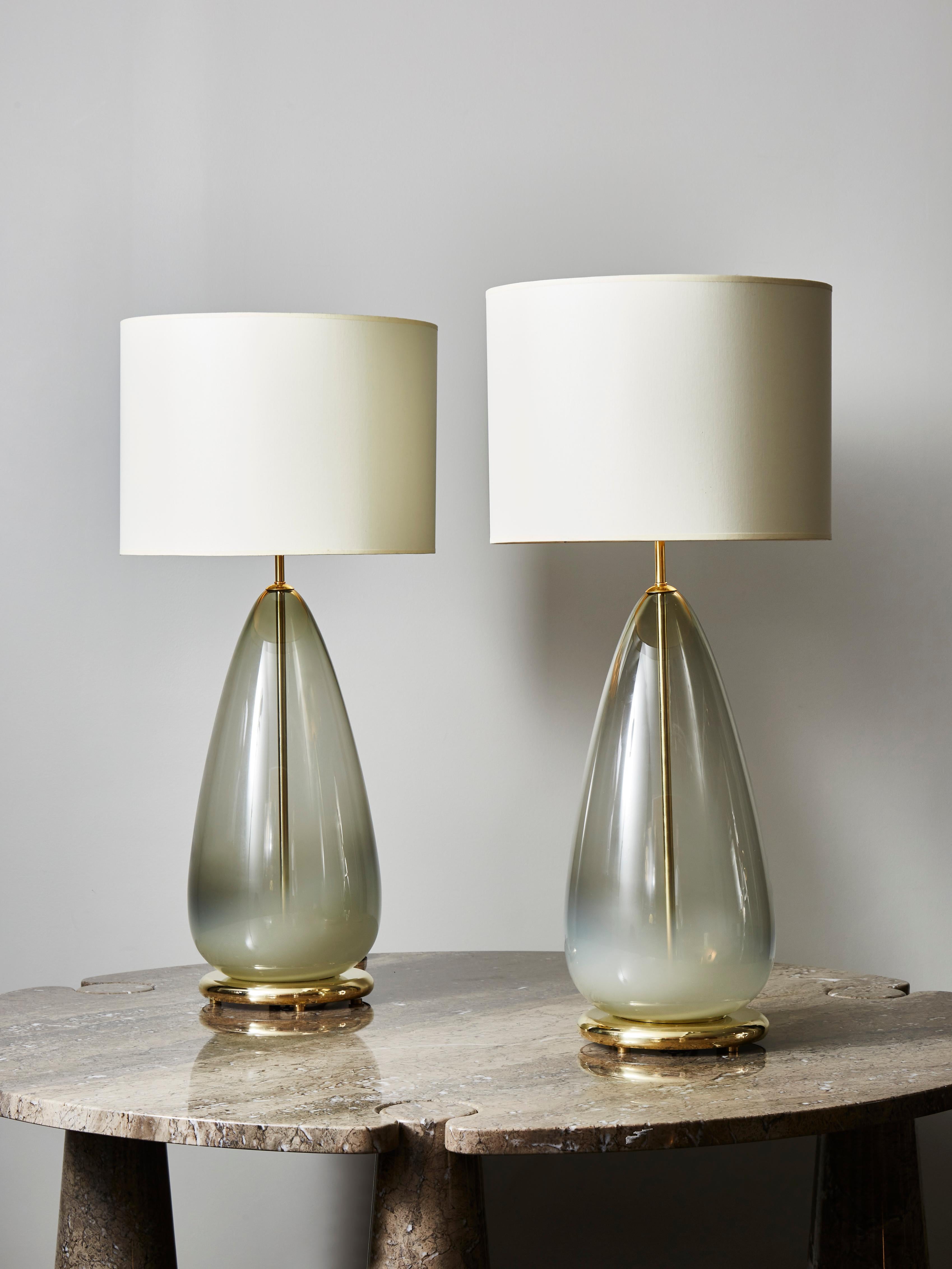 Pair of drop shaped Murano glass table lamps with a gradient grey tint, brass feet and center stem.