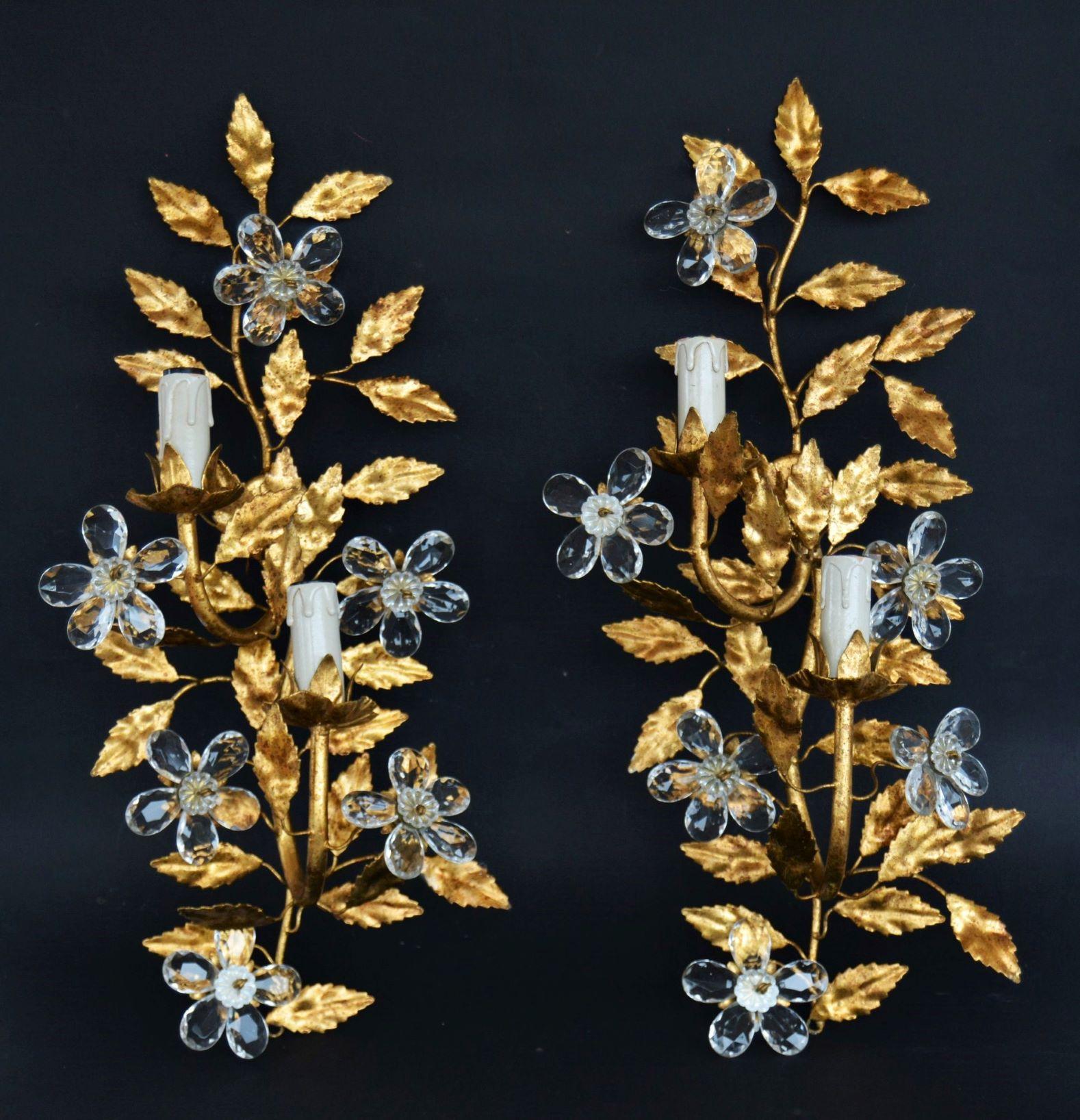 Pair of tall gold leaf two-arm wall lights in style of Maison Bagès, France, 1950s. Wonderful art environment handcrafted in wrought iron gild with gold leaf, enriched with clear crystal flowers. In excellent condition, gold leaf very well