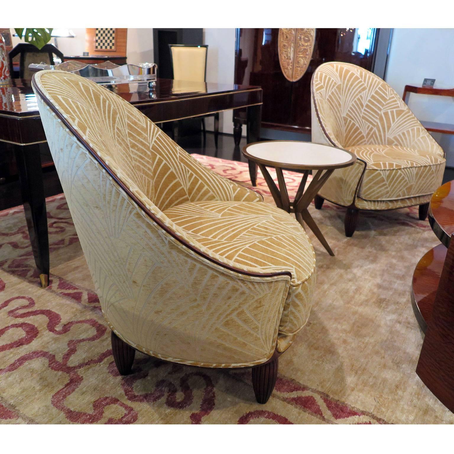 Pair of tall arched-back slipper chairs from France, circa 1930s. A thin Mahogany frame with a matte or satin finish and exposed tapered and ribbed mahogany legs. Upholstered in pale gold fan-pattern cut velvet with contrast piping.

     
