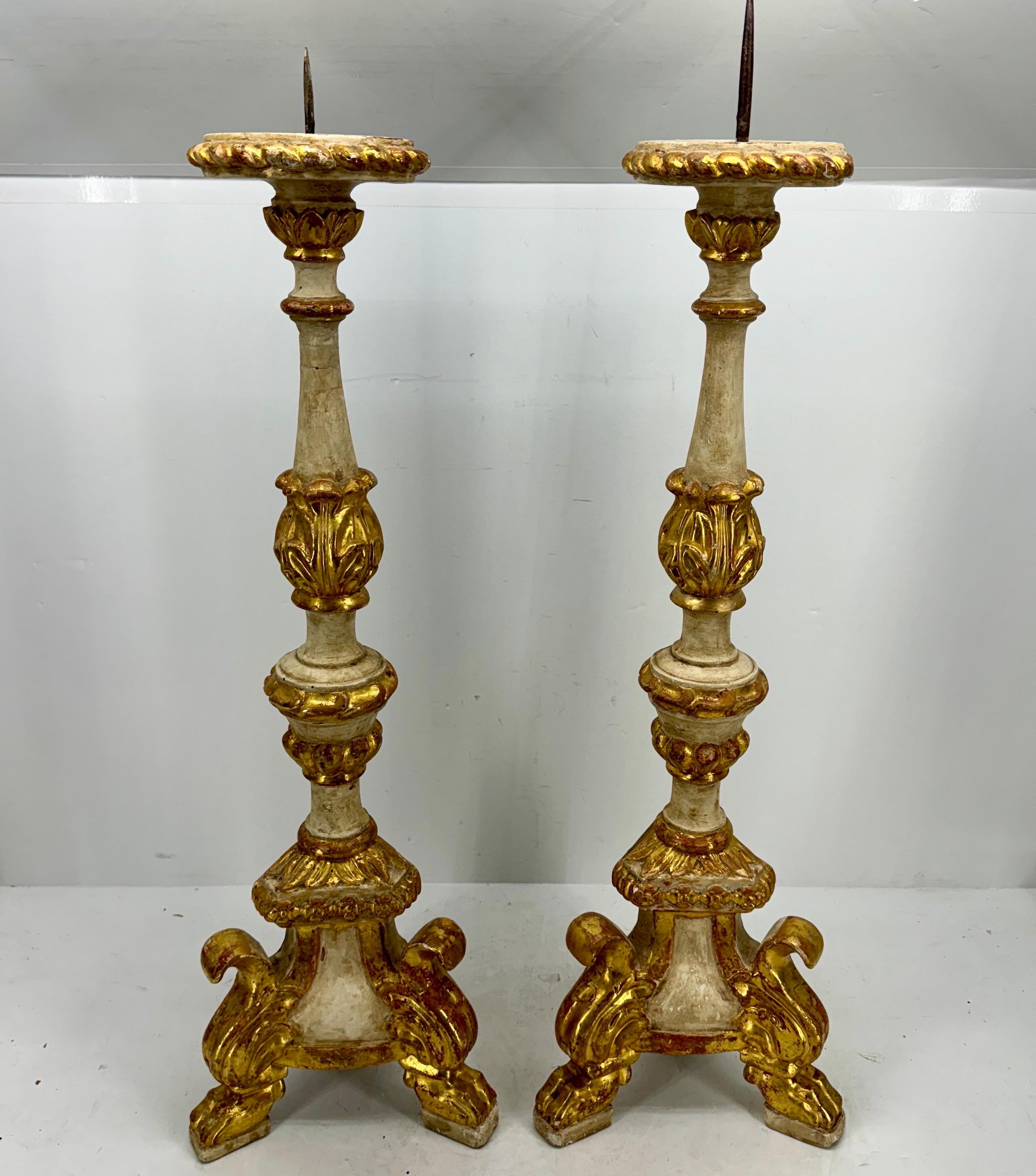 Authentic pair of carved gilded alter sticks with original paint, patina and prickets. These large untouched church pricket candlesticks are carved from wood and have iron spikes for displaying candles. Wonderful addition as a centerpiece on a long