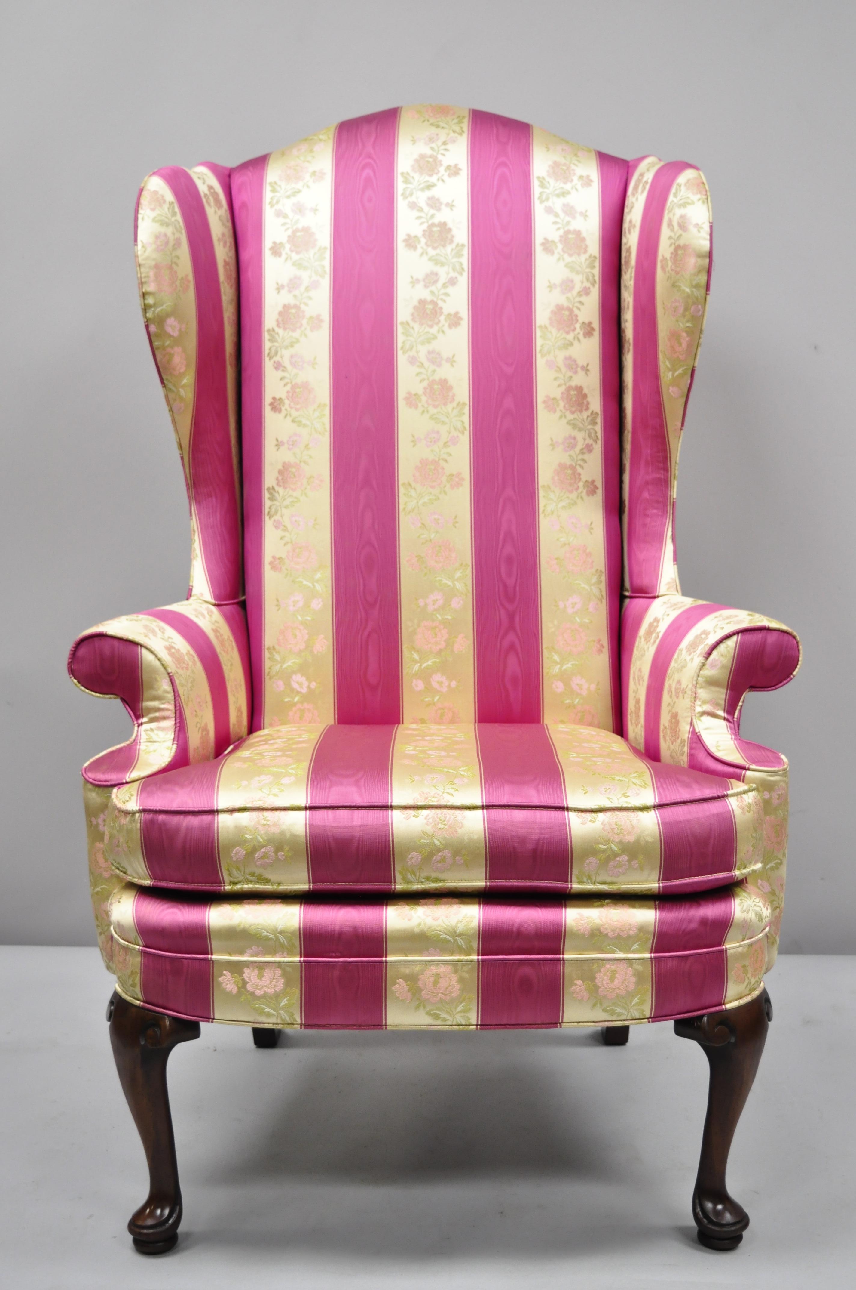 Pair of tall high back pink and gold Queen Anne wingback armchairs by Statesville Chair Company. Listing features tall and stately high backs, pink and gold stripe floral print fabric, queen anne legs, rolled arms, solid wood frame, original label,