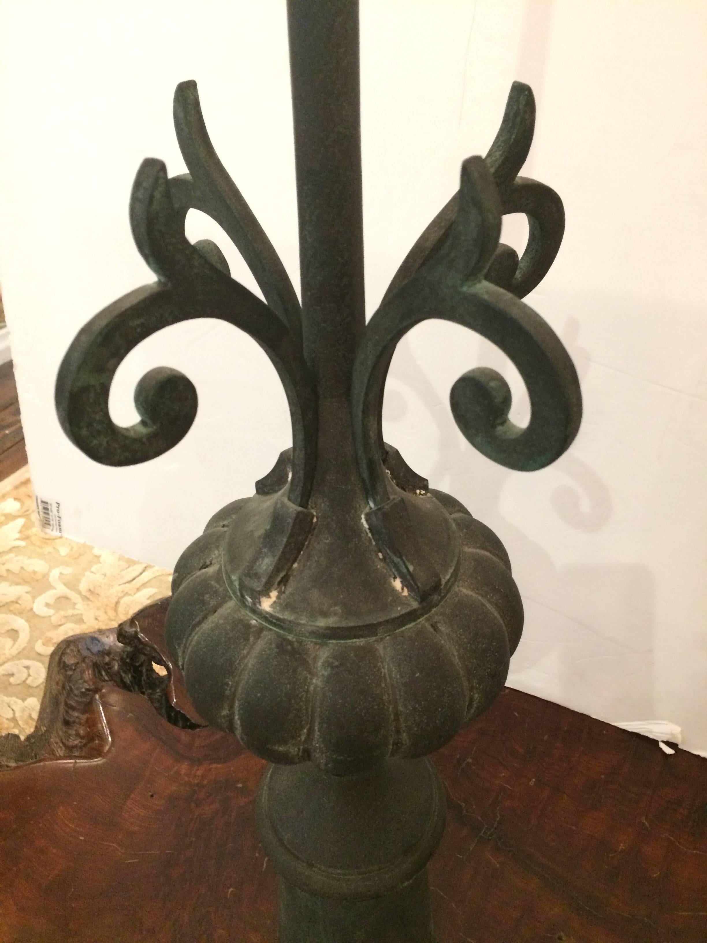 Two handsome dark grey iron finials having a central tall spike and curlicues on a fluted bulb and column base. Have an aged appearance.