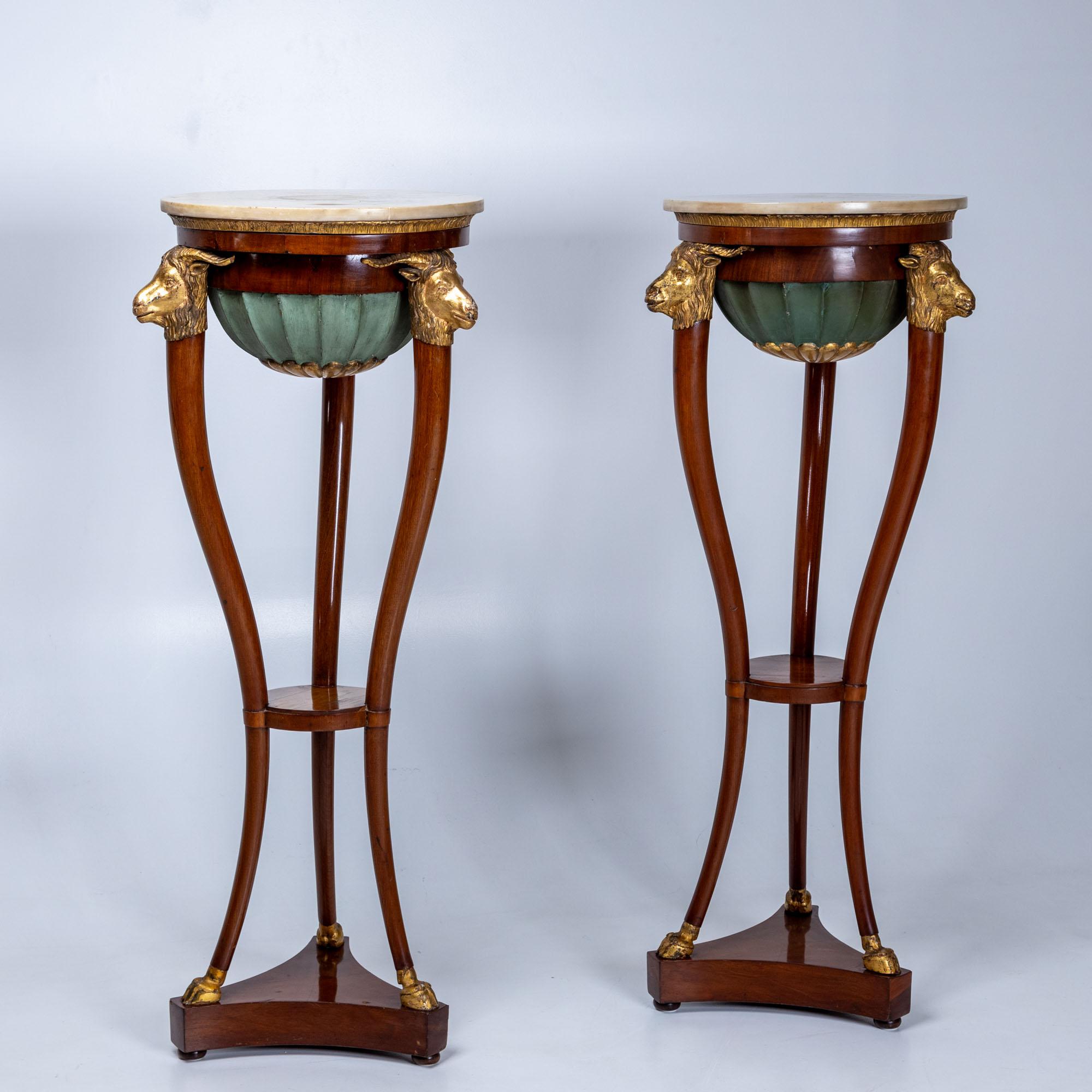 Une paire raffinée de torchères italiennes en acajou, datant du début du XIXe siècle et probablement originaires de Naples. Les torchères reposent sur des bases tripodes dont les pieds élégamment incurvés se terminent par des sabots stylisés, ornés