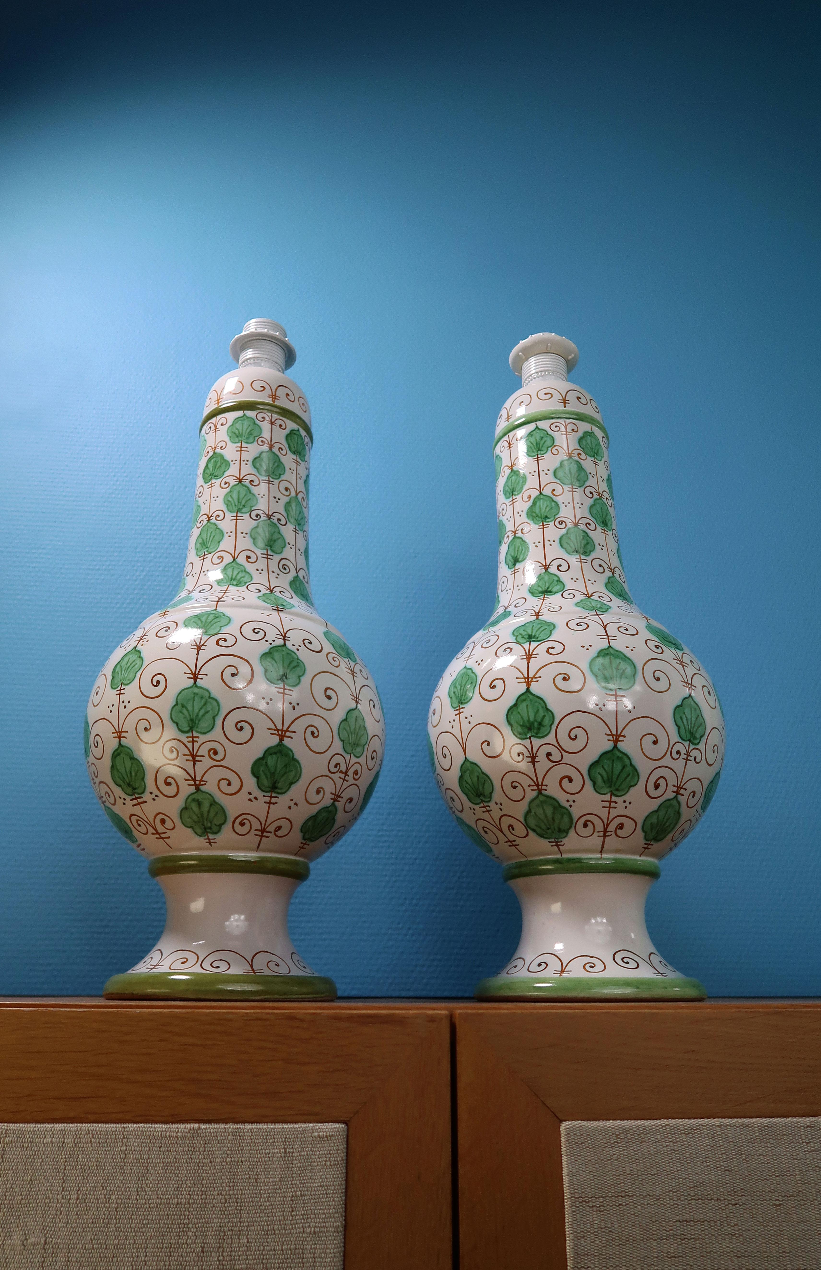 Exceptionnelle paire de lampes de table en céramique italiennes du milieu du siècle dernier, hautes et courbes. Base émaillée blanche avec des feuilles vertes au toucher tropical peintes à la main et des lignes courbes brun caramel et un décor
