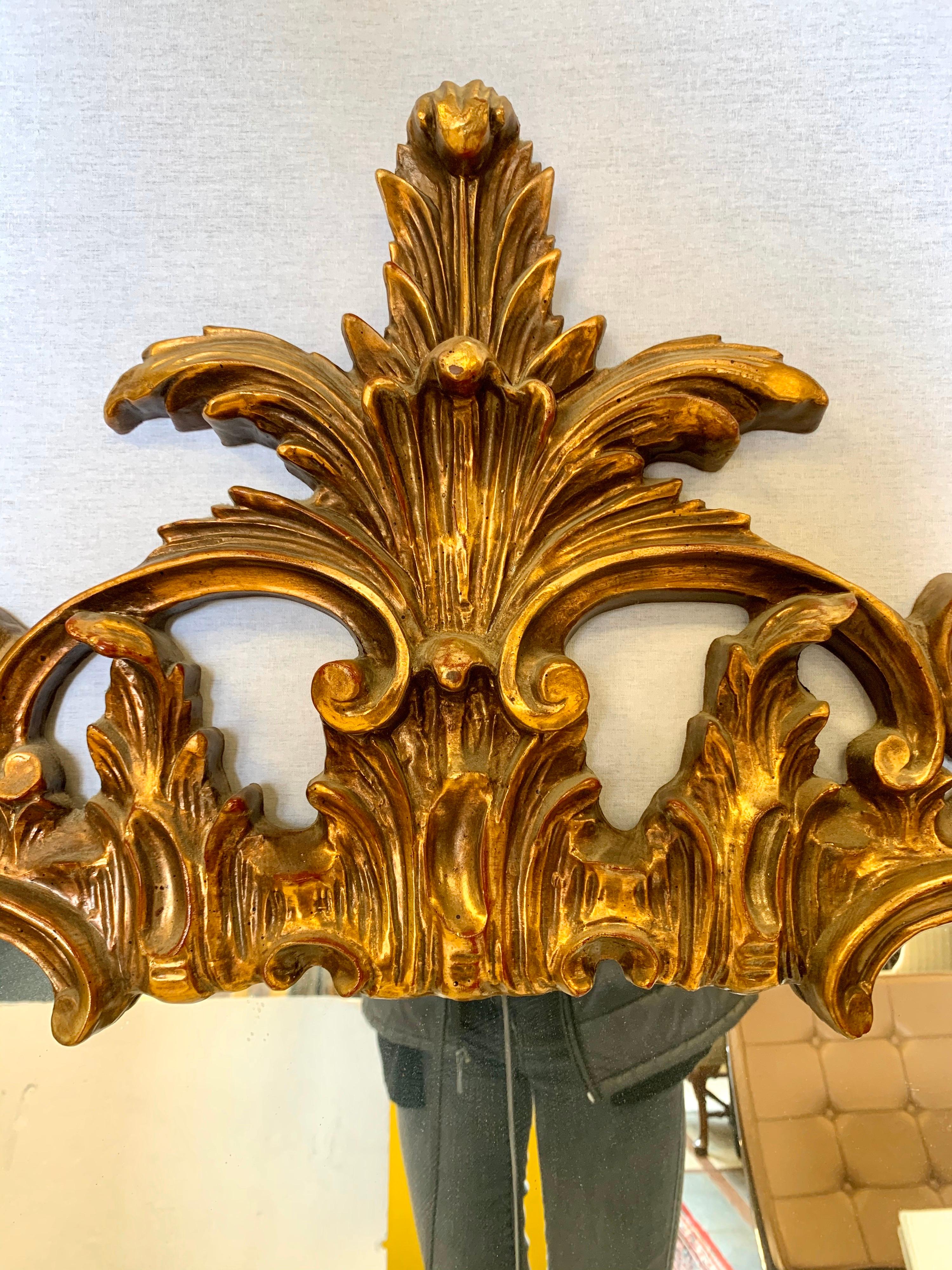 Elegant pair of tall matching giltwood mirrors with carved acanthus leaf detail and open scrollwork on top and bottom.