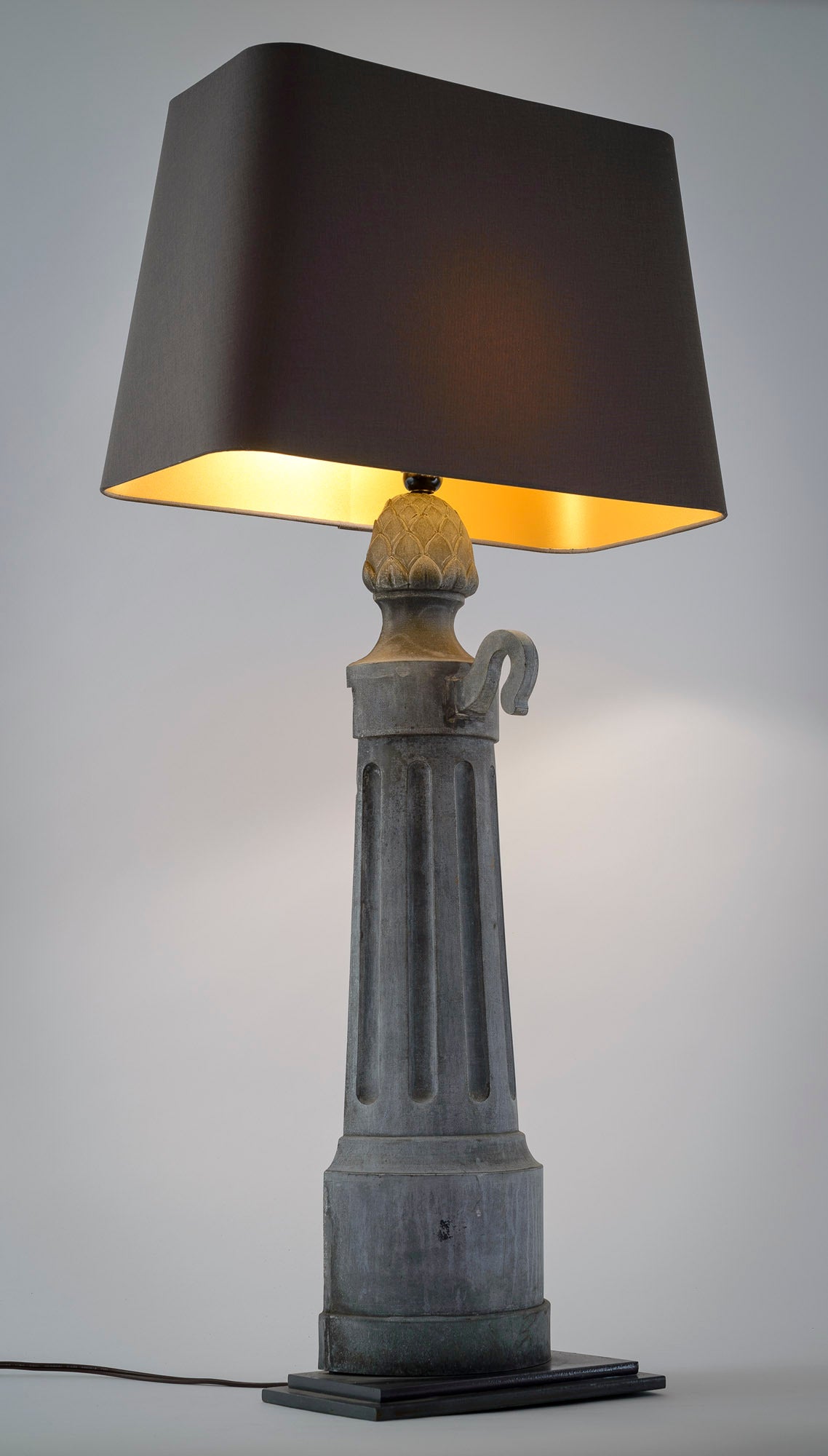 This pair of strikingly interesting lamps are repurposed metal object. The lamps are mounted on a simple two stage base. The gunmetal linen shades have a rich gold liner and a high low in-line switch. The lamps have been rewired for US use. When