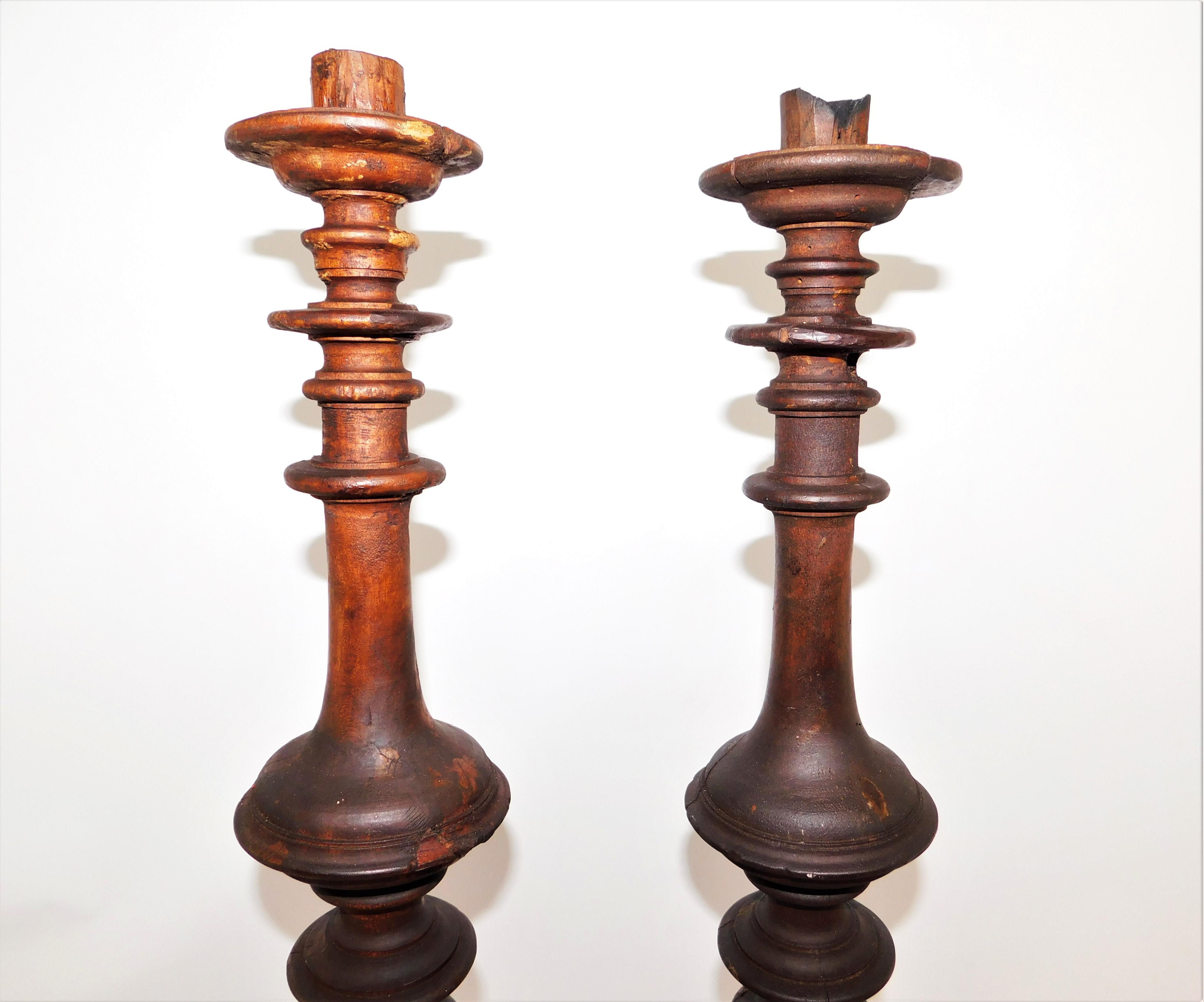 Pair of tall architectural pieces mid-19th century traditional rustic wood candlesticks. Hand carved by an unknown manufacturer, European. In original condition, wear consistent with age and use, preserving a beautiful patina of these almost 200