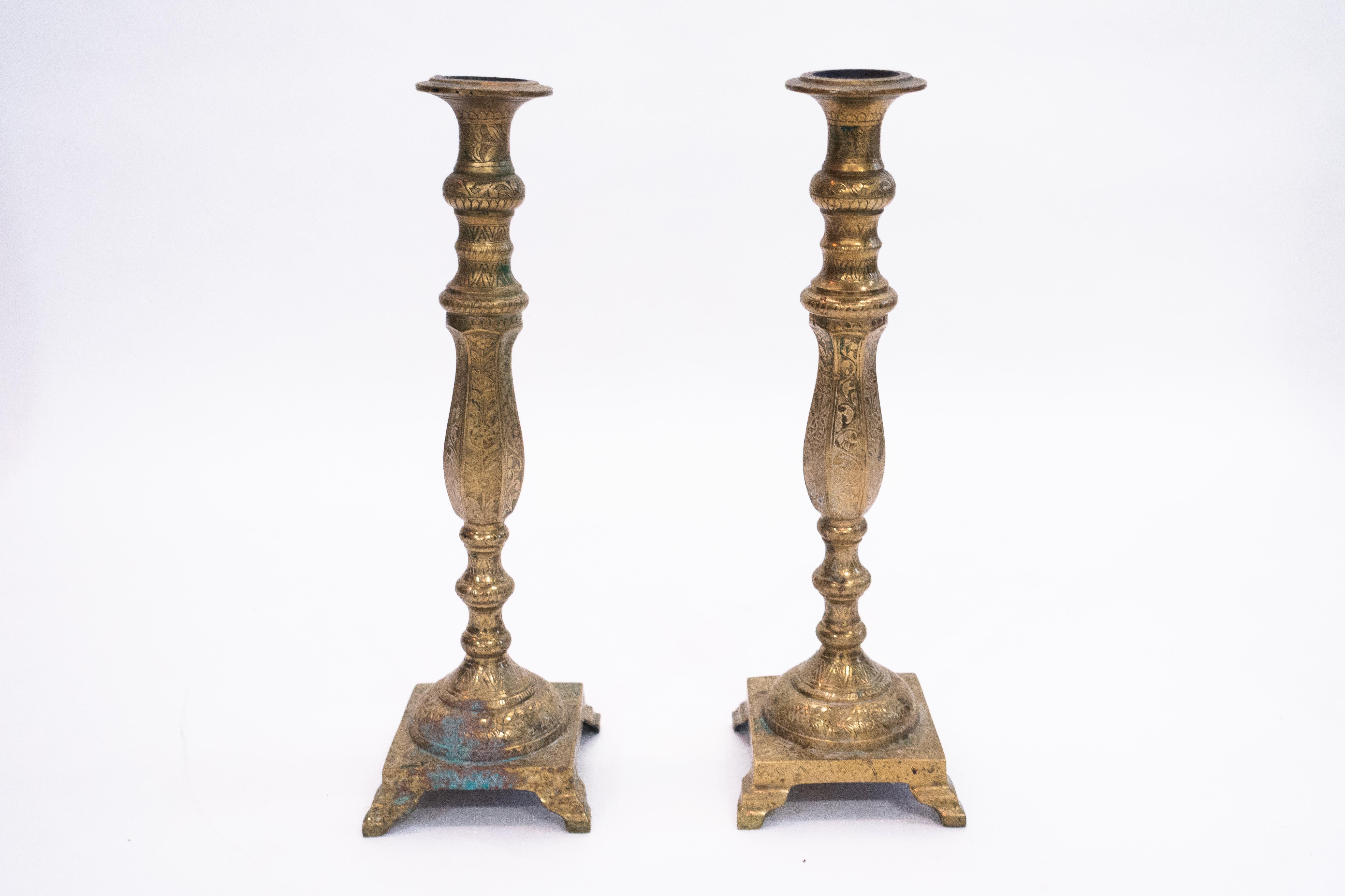 Pair of tall Moroccan brass candlesticks from the 1950s decorated in very detailed arabesque floral and geometric design.