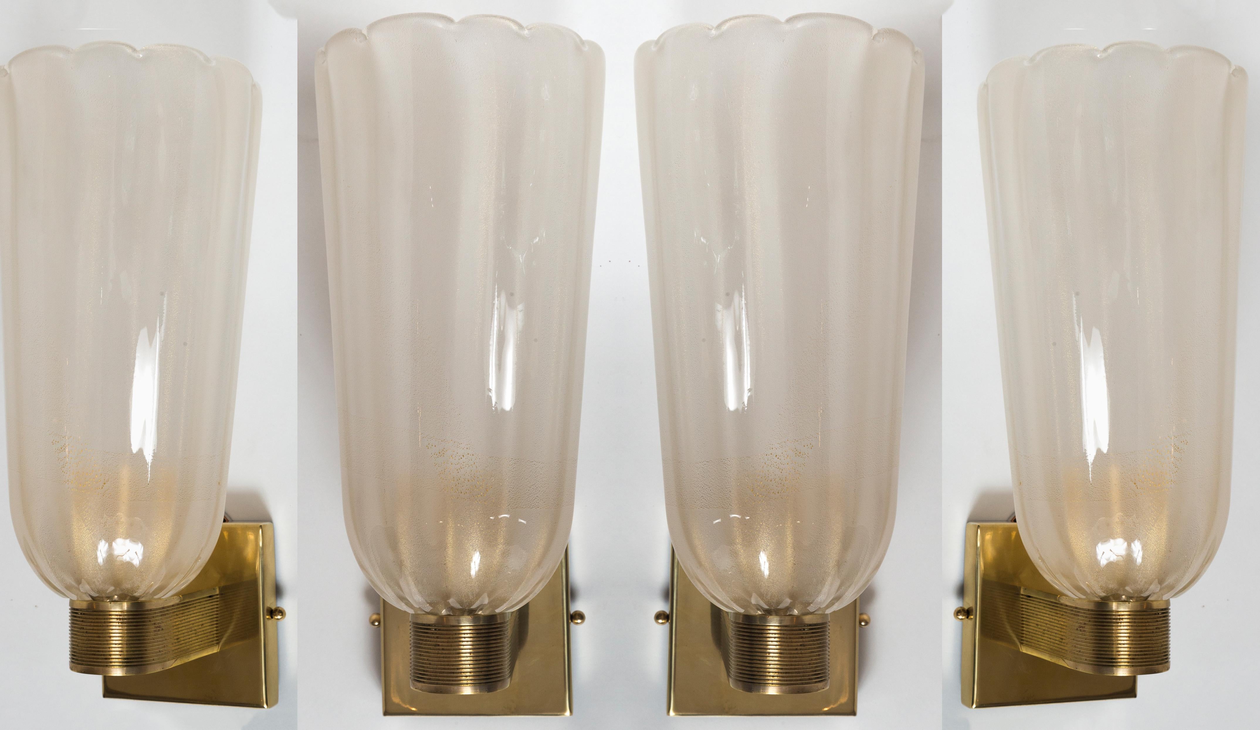 An elegant pair of modernized Art Deco style mouth blown wall lights composed of tall and lightly scalloped lattimo gold cups upheld by sleek unlacquered brass arms.

Wired with porcelain E26 , install ready with 5? x 5? back plate and UL