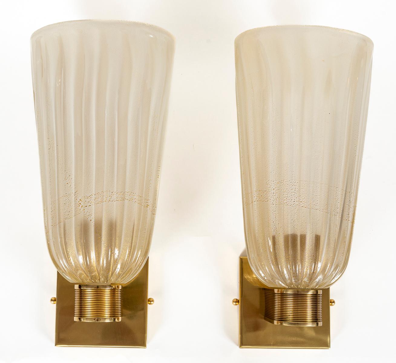 An elegant pair of modernized Art Deco style mouth blown wall lights composed of tall and oval gold cups upheld by sleek unlacquered brass reeded arms.

Wired with porcelain E26 , install ready with 5