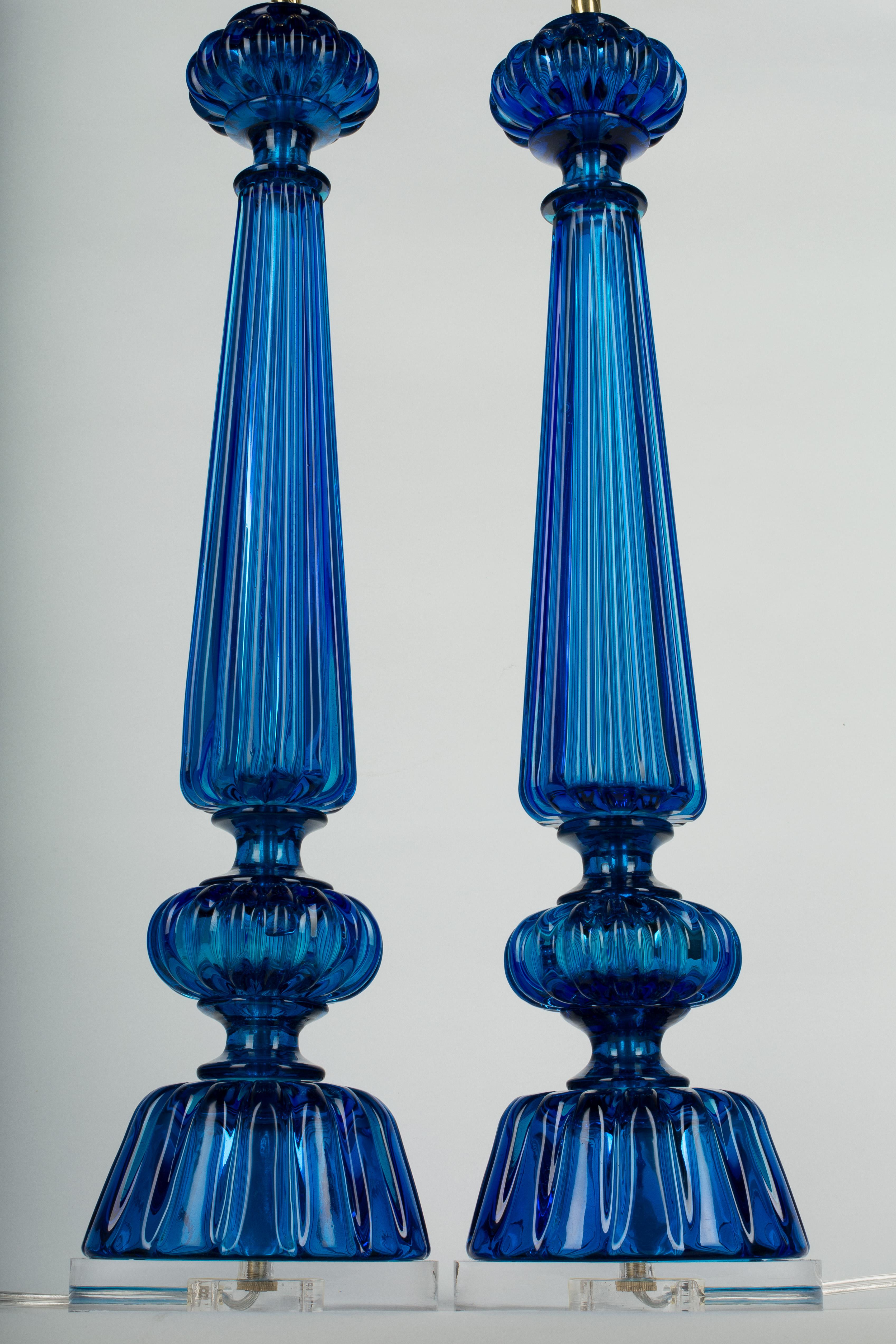 A pair of tall Mid-Century Modern Murano glass lamps by Seguso comprised of four cobalt blue glass parts. Original polished brass fittings. Rewired with new 3-way sockets and new Lucite bases.