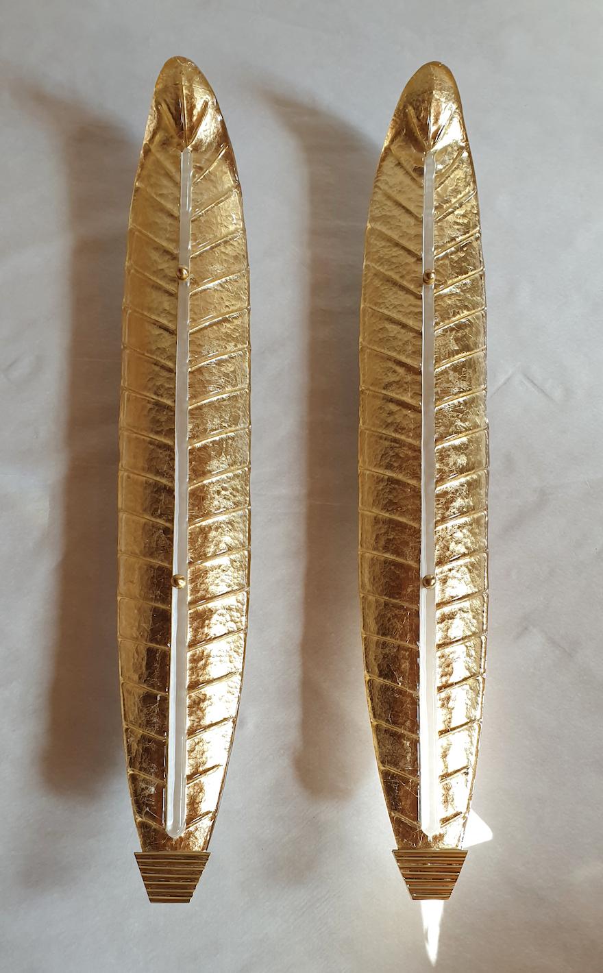 Pair of very tall and thin Mid-Century Modern Murano glass sconces, Barovier & Toso style, Italy 1970s.
Made of brass mounts with a beautiful patina, and gold Murano glass leaves.
The gold inside the sconces create a warm translucent light effect,