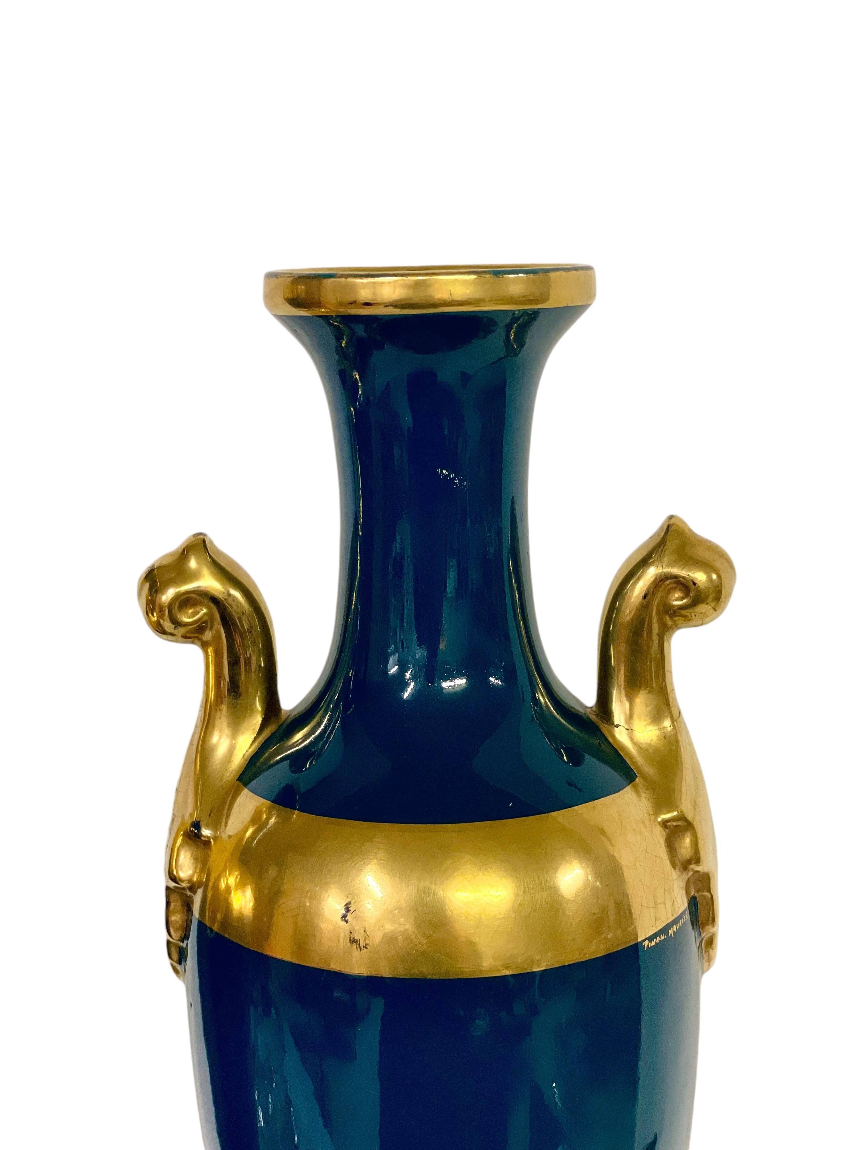 Questa coppia di vasi alti in porcellana firmata è realizzata in stile Eleg, incarnando eleganza e grandezza. Ogni vaso è caratterizzato da uno smalto verde acqua intenso, evidenziato da ornamentali accenti dorati, tra cui una fascia intorno al