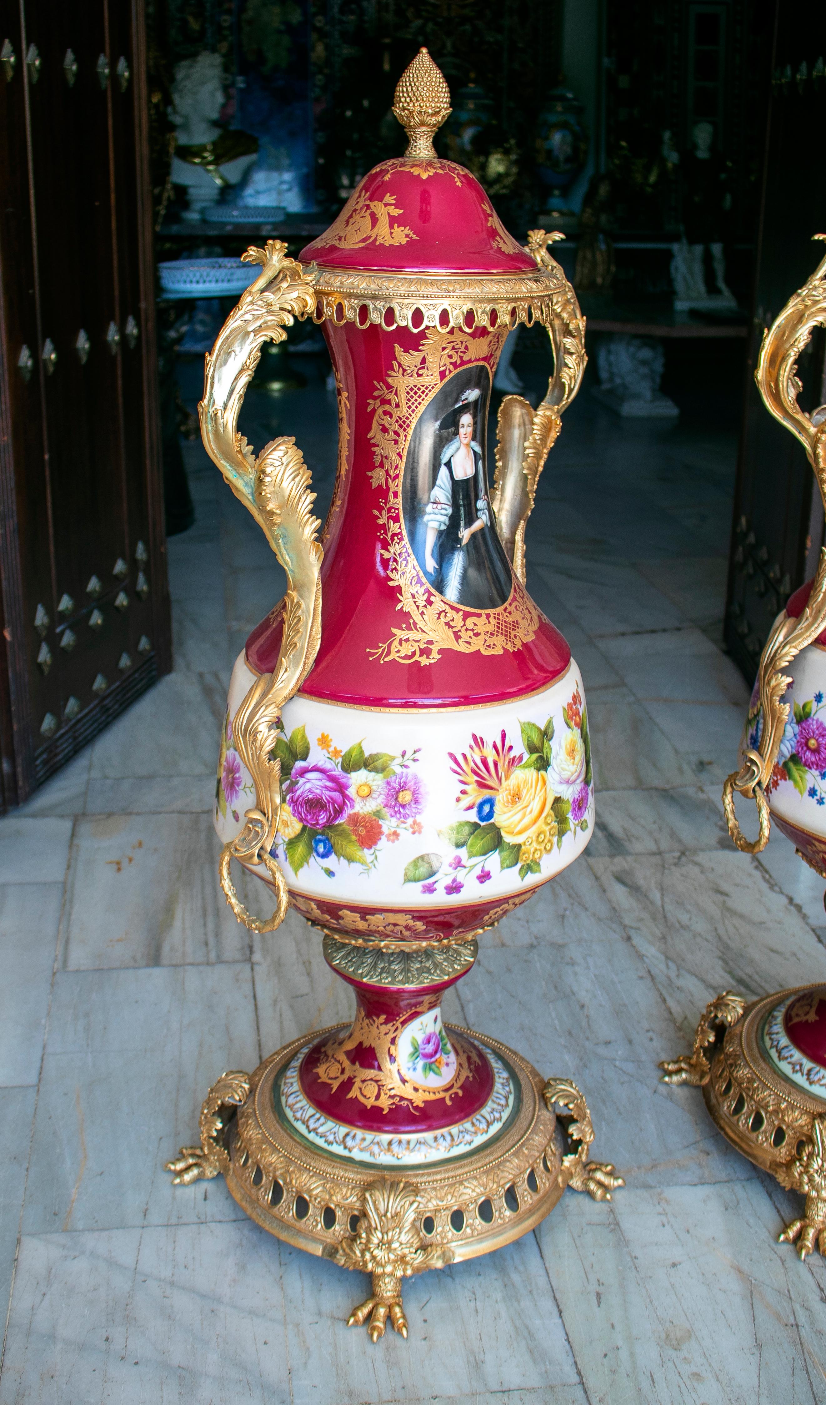 Pair of tall porcelain urns hand painted with costumbrist scenes.