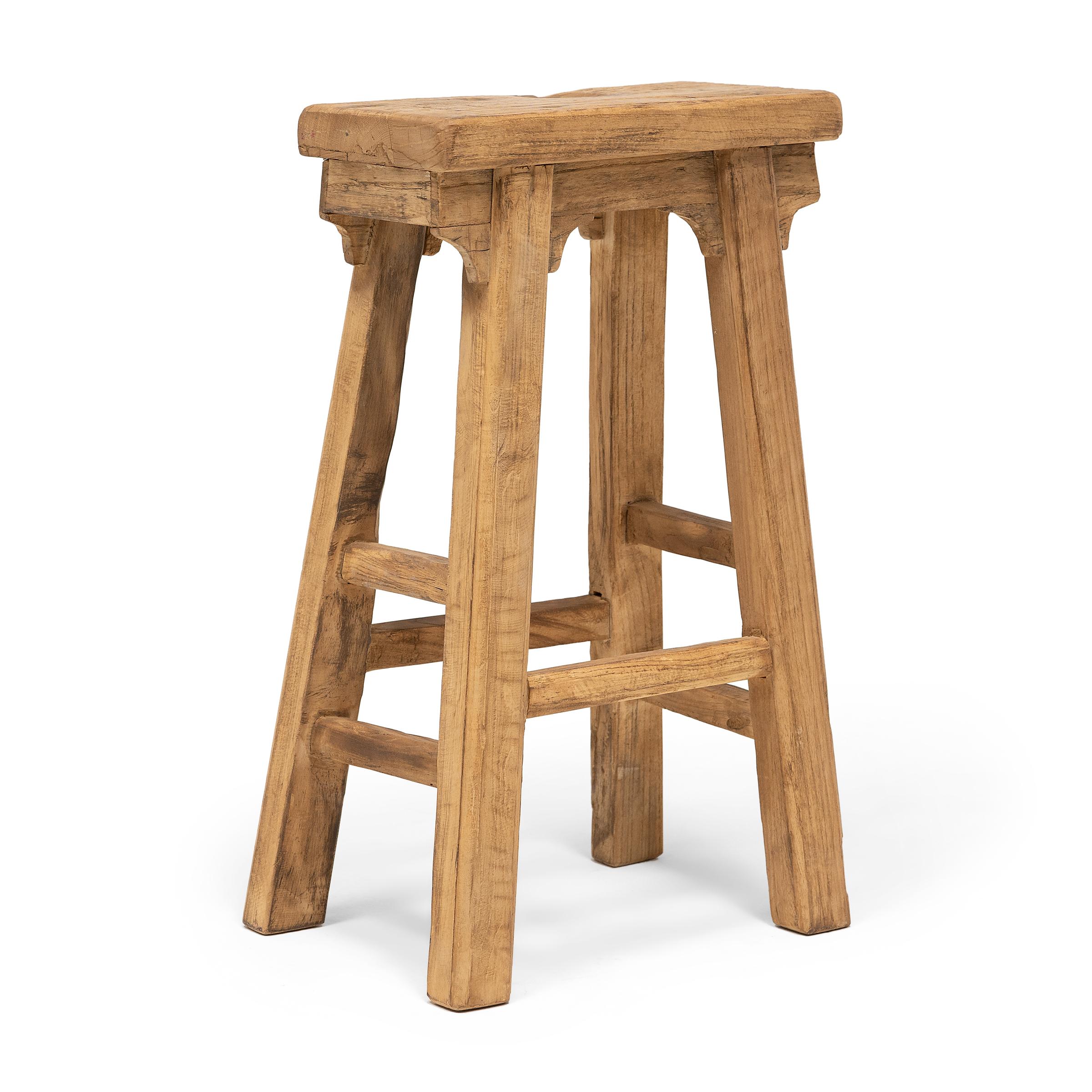 This provincial stool is artisan-crafted in the style of traditional Chinese courtyard stools typically used throughout a Qing dynasty home as versatile everyday seating. Made of reclaimed elmwood, the tapered stool features a narrow, rectangular