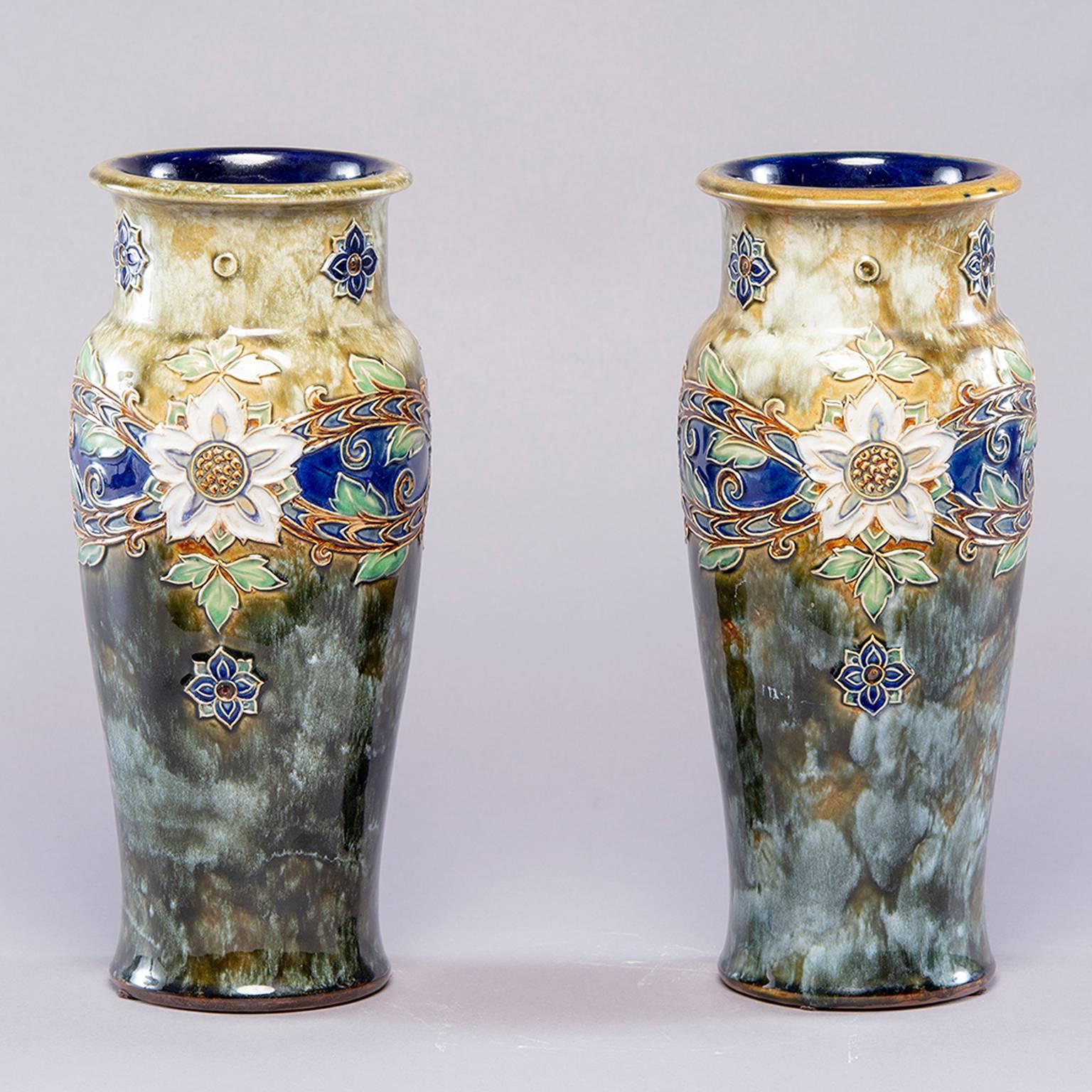 Pair of tall Royal Doulton Lambeth vase by Winnie Bowstead, circa 1920s. These large and striking pieces are decorated in the Art Nouveau style. The Royal Doulton impressed mark is on the underside of the base along with the and the incised initials