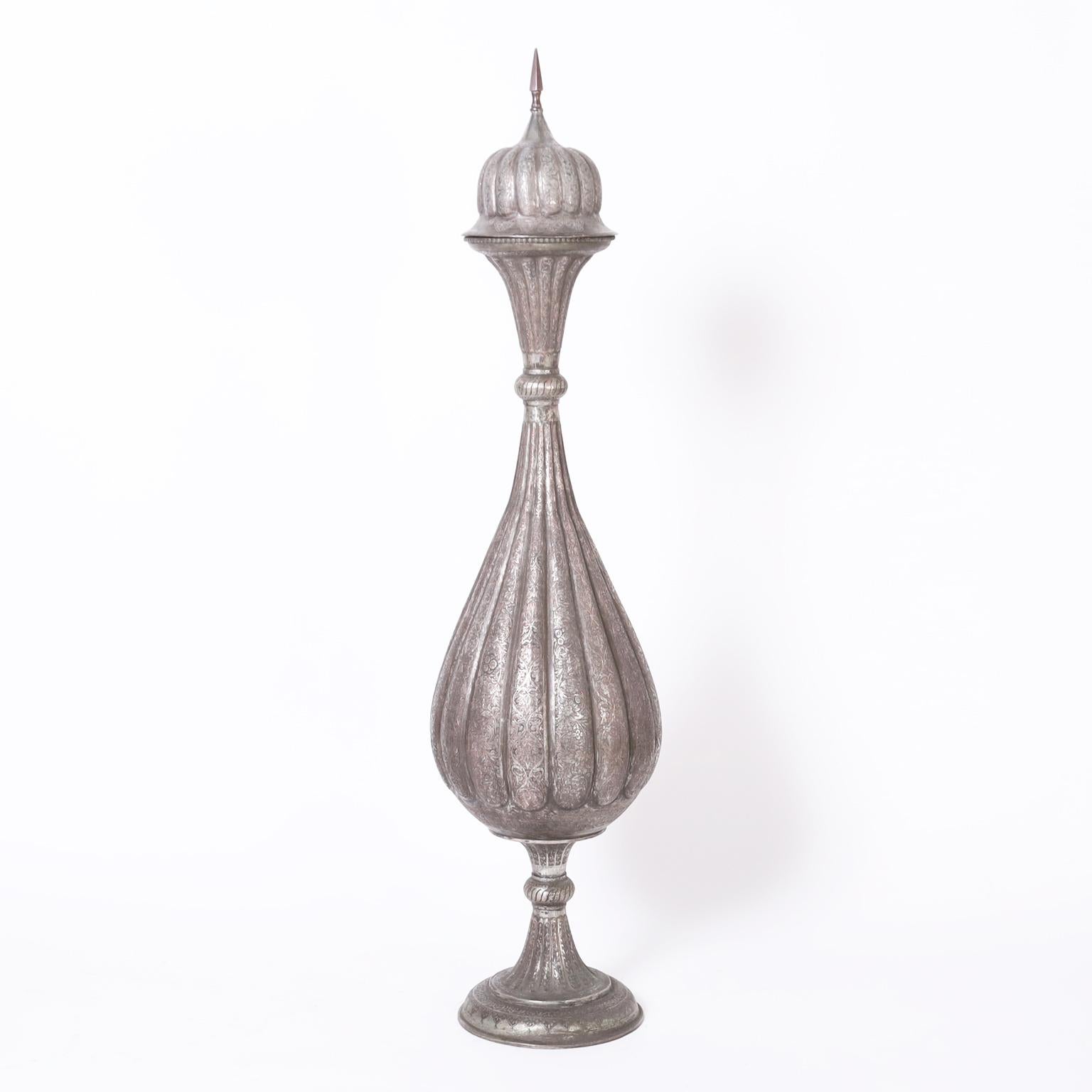 Stand out pair of antique Anglo Indian lidded urns handcrafted in silver on copper in a dramatic exotic form featuring ambitious hand engraved floral designs throughout. Best of the genre.