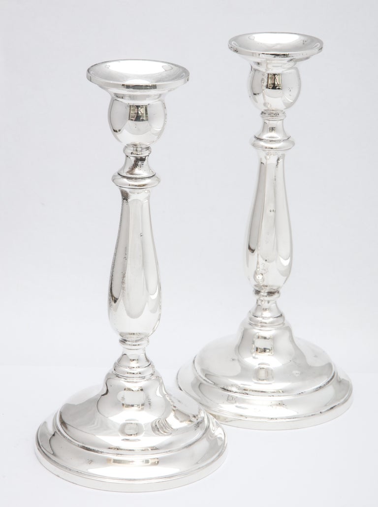 Pair of tall sterling silver, Empire-style candlesticks, Wallingford, Connecticut, Simpson, Hall, Miller Co. (Division of International Silver Co.), circa 1910. Pair measures 9 1/8 inches high x 4 1/8 inches diameter across base of each. Weighted.