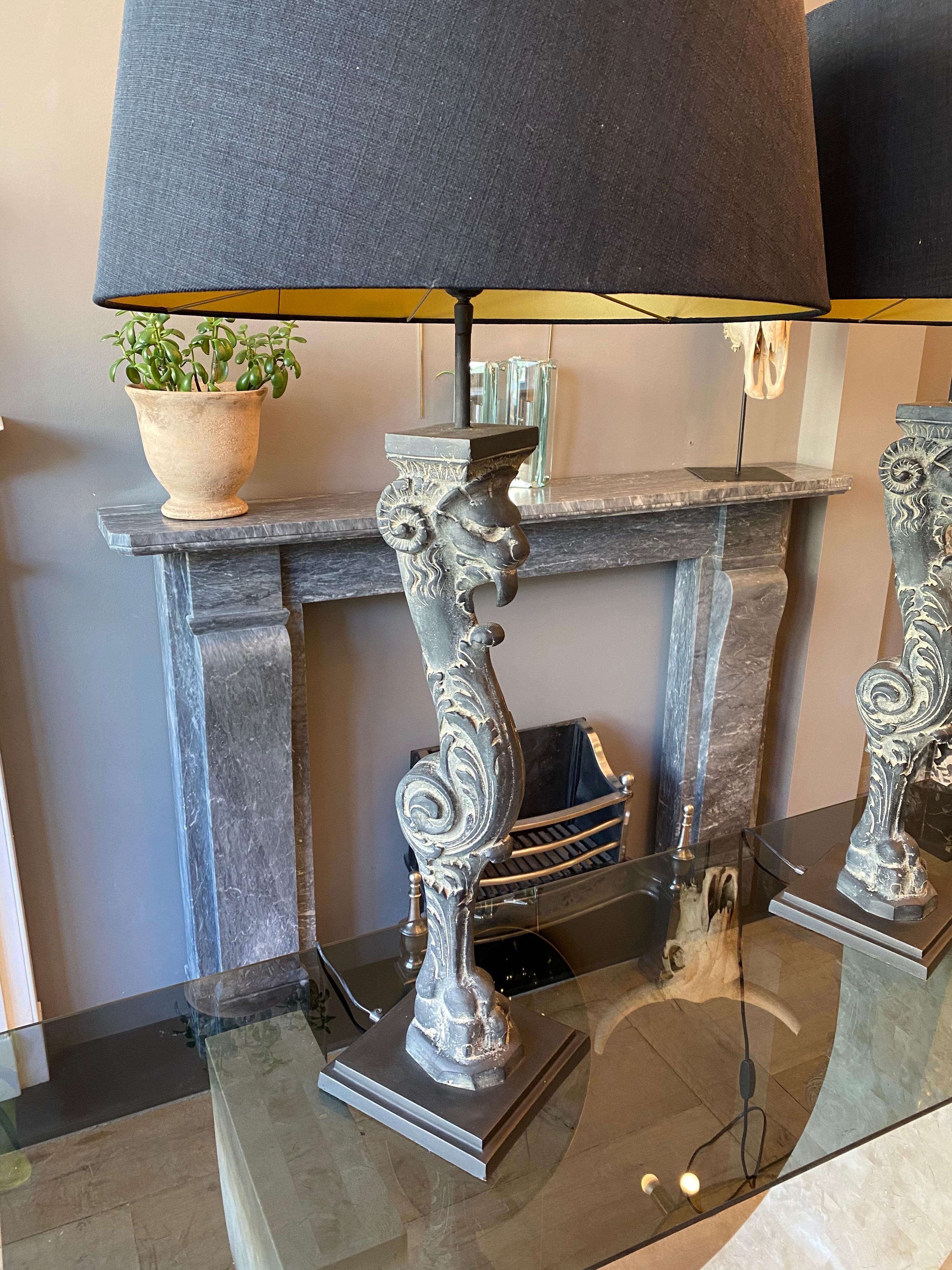 A large pair of stone monopedia table lamps on square plinth bases. The black fabric shades with gold interior lining. A good quality pair of lamps, late 20th century.