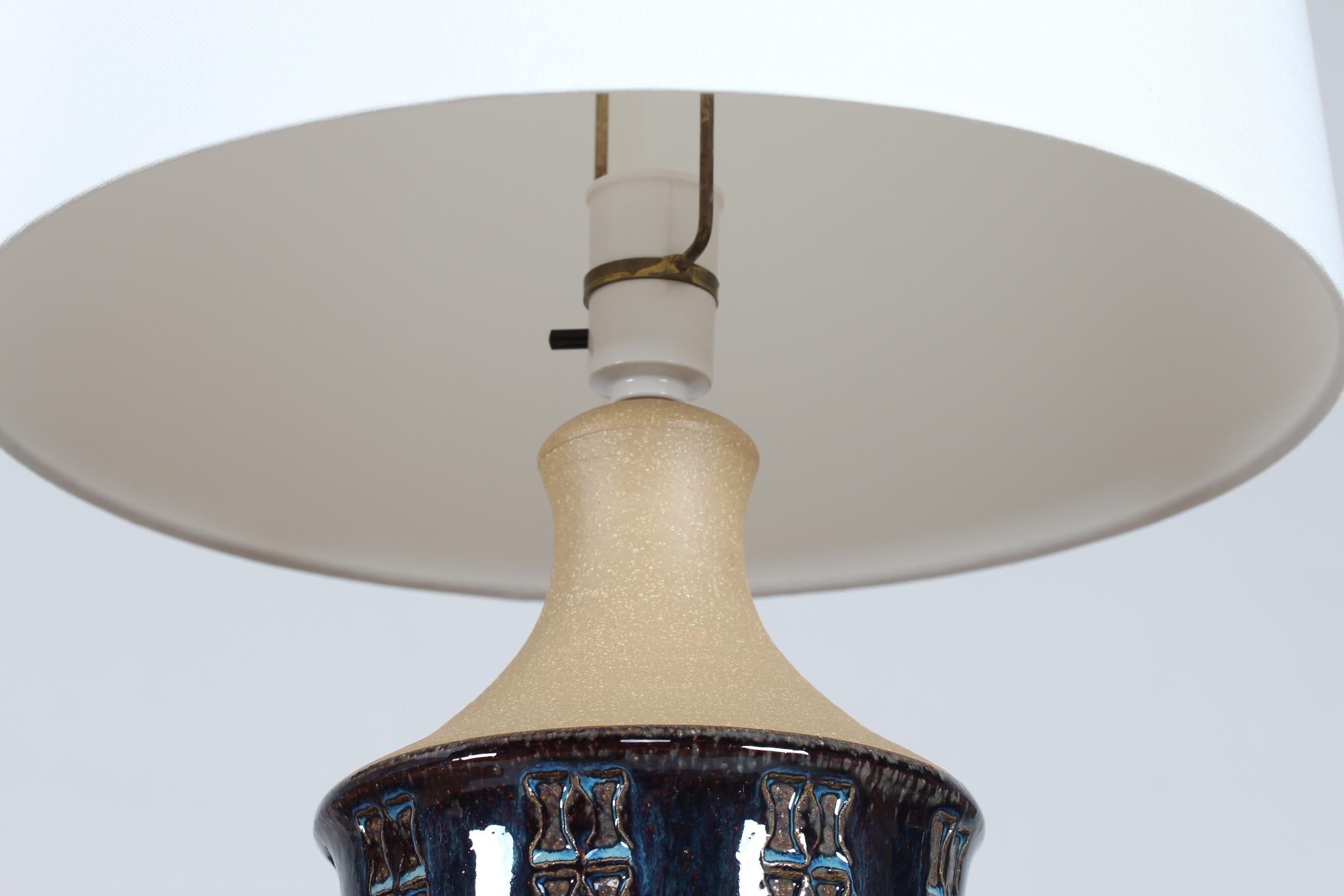 A pair of tall stoneware table lamps designed by Maria Philippi and made by the pottery Søholm on the island of Bornholm in Denmark in the 1960´s.
The lamp base is decorated with an embossed pattern in bands and glossy glaze in blue colors - the