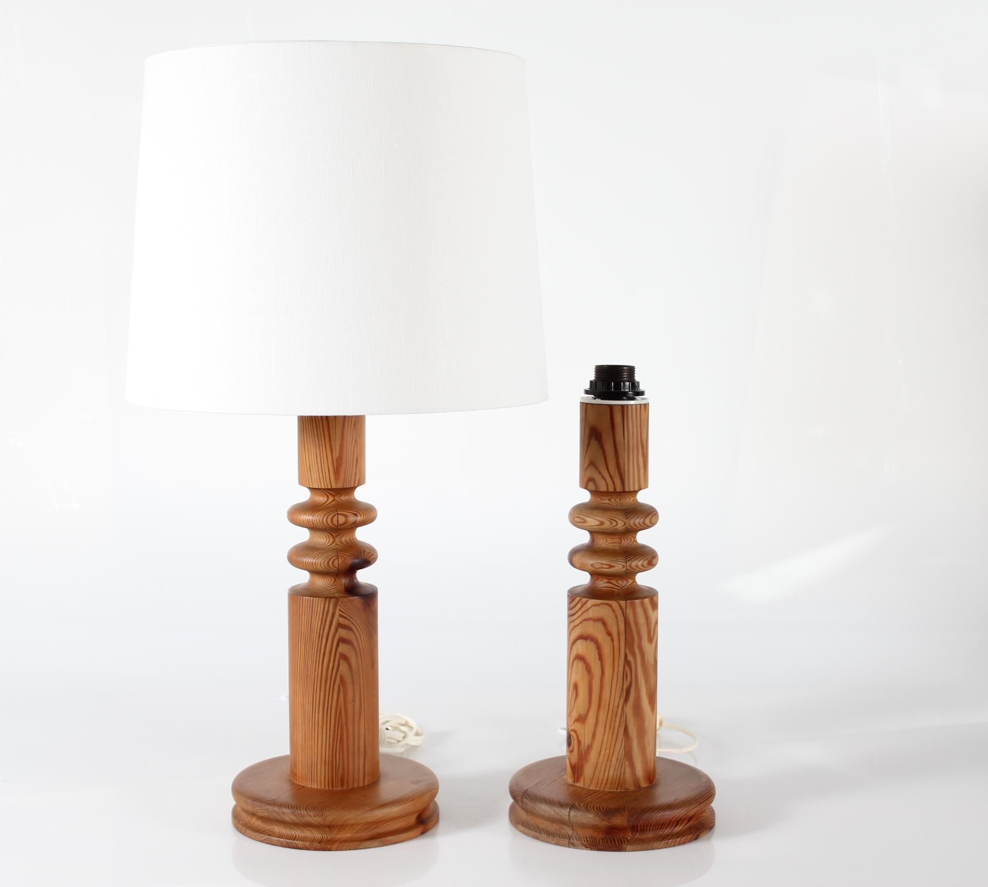A pair of tall sculptural Uno Kristiansson table lamps made of solid turned pine, Sweden 1970s. 

Measures: 
Height incl. lamp shade 71 cm
Height lamp base incl. socket 44 cm
Height lamp base wooden part only 41 cm
Diameter lampshade ca. 40