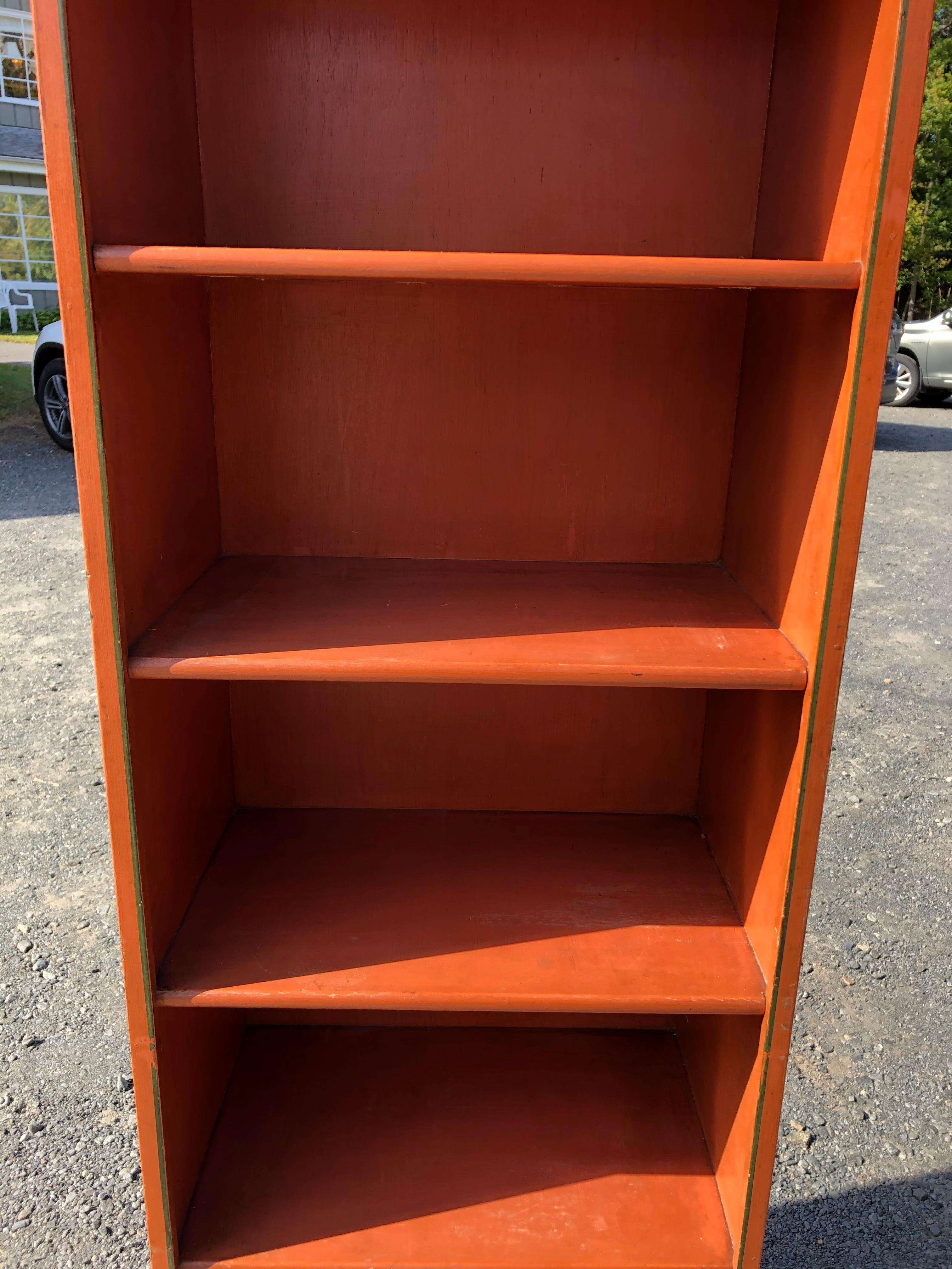 Tall narrow stunning pair of English vintage terracotta painted narrow bookcases with classical pediments and bracket feet, pinstriped in dark green.