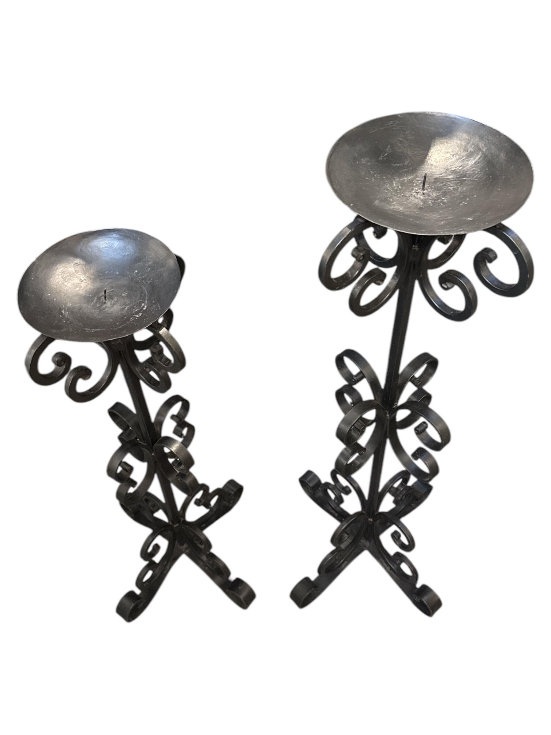 Add a touch of timeless elegance to your home with this Pair of Tall Wrought Iron Curly Floor Candle Holders. Expertly handcrafted, these striking candle stands feature gracefully curved ironwork, offering a perfect blend of classic charm and modern