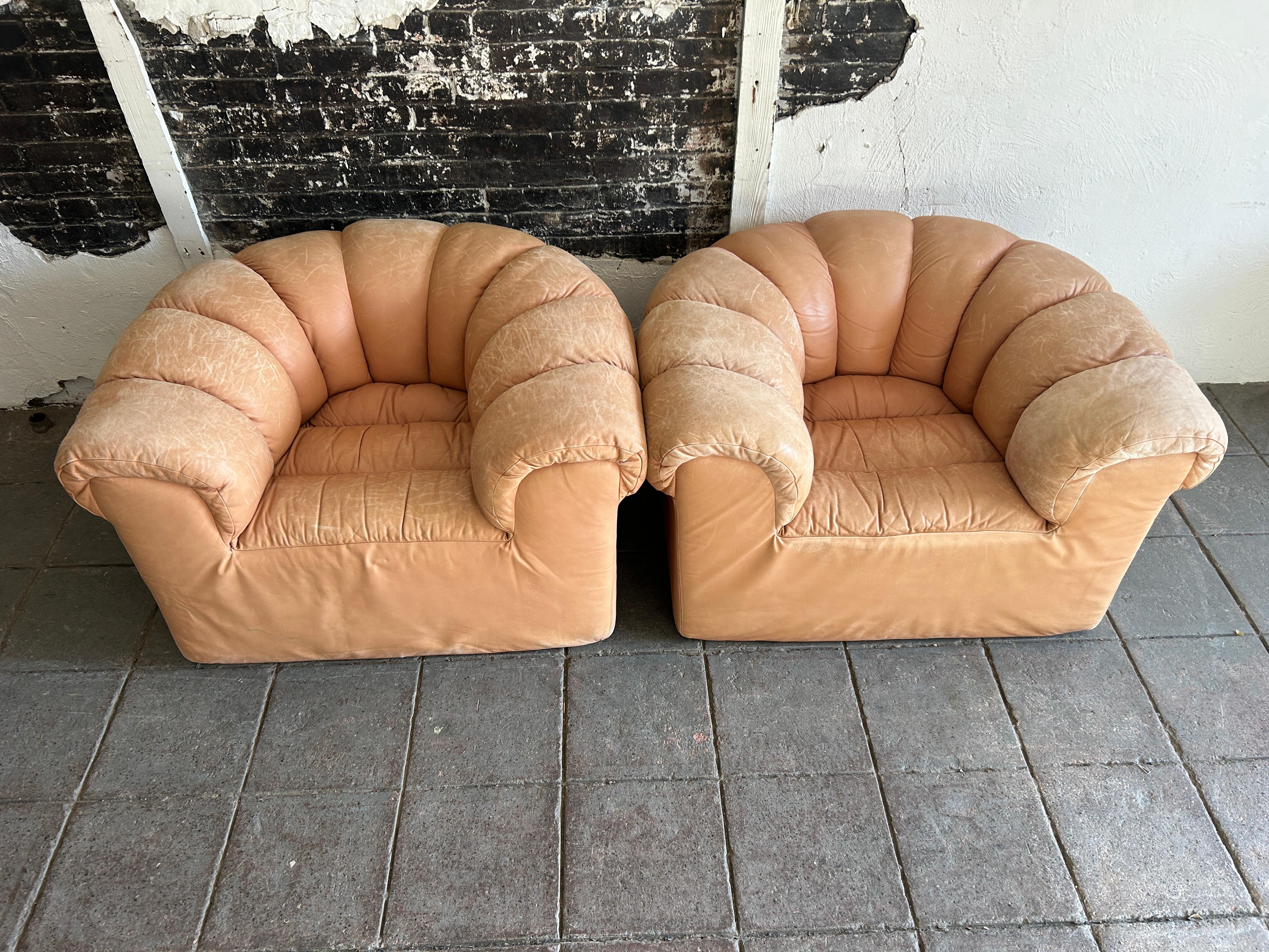 Pair of tan leather Dutch croissant puffy low lounge chairs all one piece molded foam structure with leather upholstery. Leather shows fading and scuffs due to age. Very comfortable chairs.

Dimensions: H 26