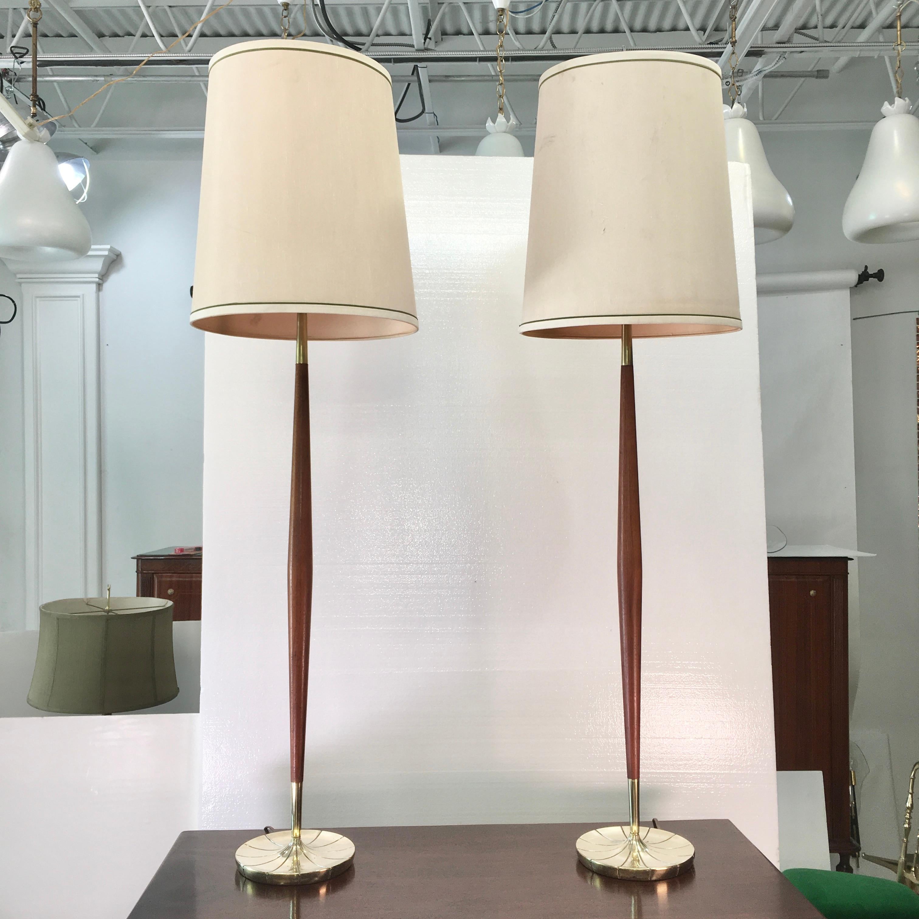 Handsome Mid-Century Modern pair of Stiffel lamps with elongated tapered walnut stems on brass finished cast aluminum petal form bases. These can be used either as petite floor lamps or extra tall table lamps. Each takes a single standard size