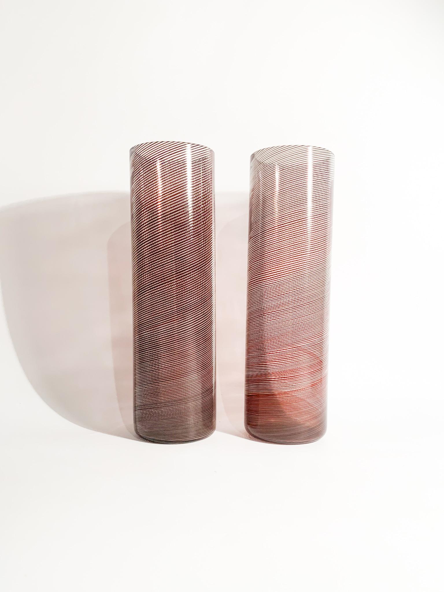Paire de vases de forme cylindrique, avec filigrane en spirale, conçus par Tapio Wirkkala et fabriqués par Venini dans les années 1970.

Ø cm 8 h cm 27

Tapio Veli Ilmari Wirkkala (Hanko, 2 juin 1915 - Helsinki, 19 mai 1985) était un designer et