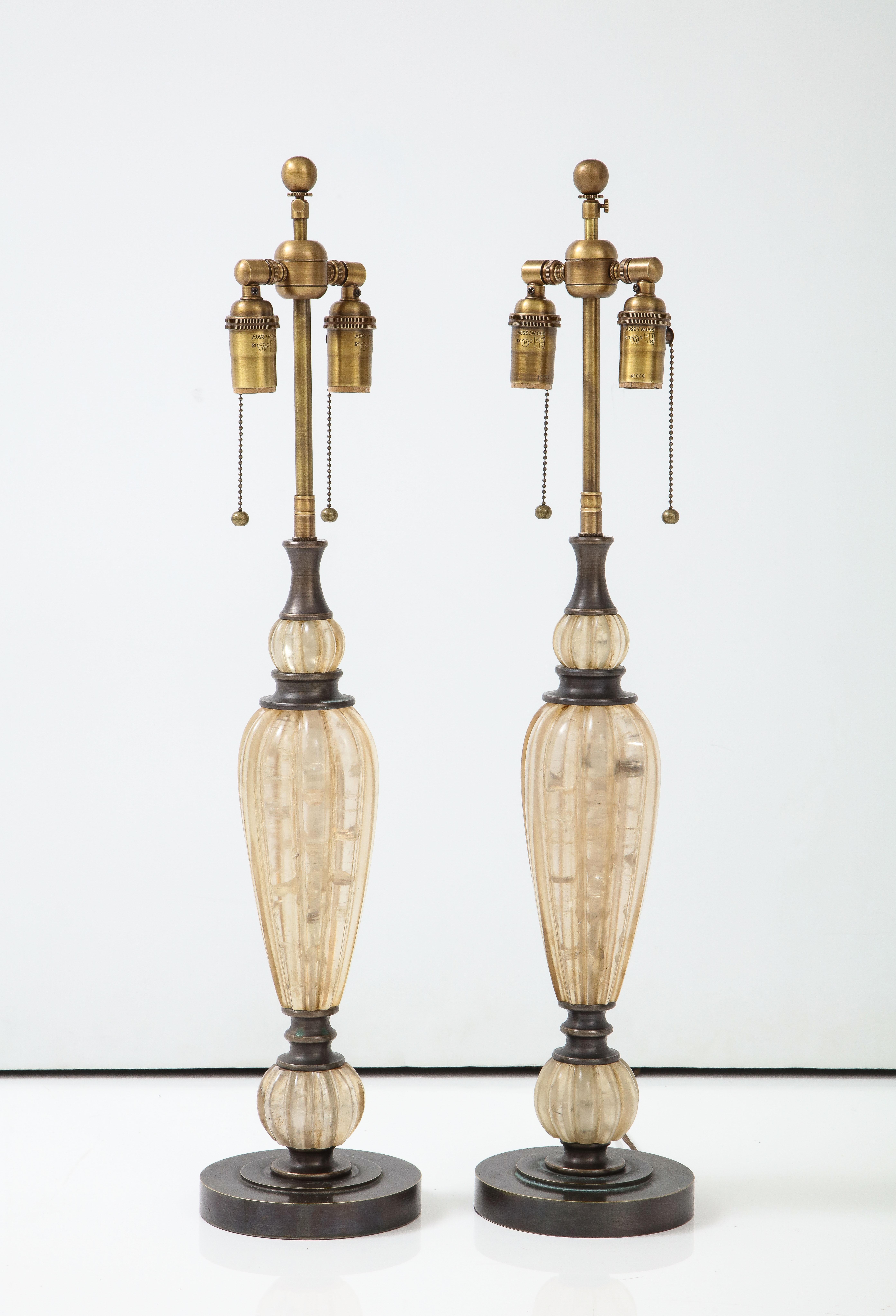 Pair of Taupe colored Resin lamps with bronzed finished hardware.
The lamps have been Newly rewired with adjustable Bronzed double clusters and Rayon cords.