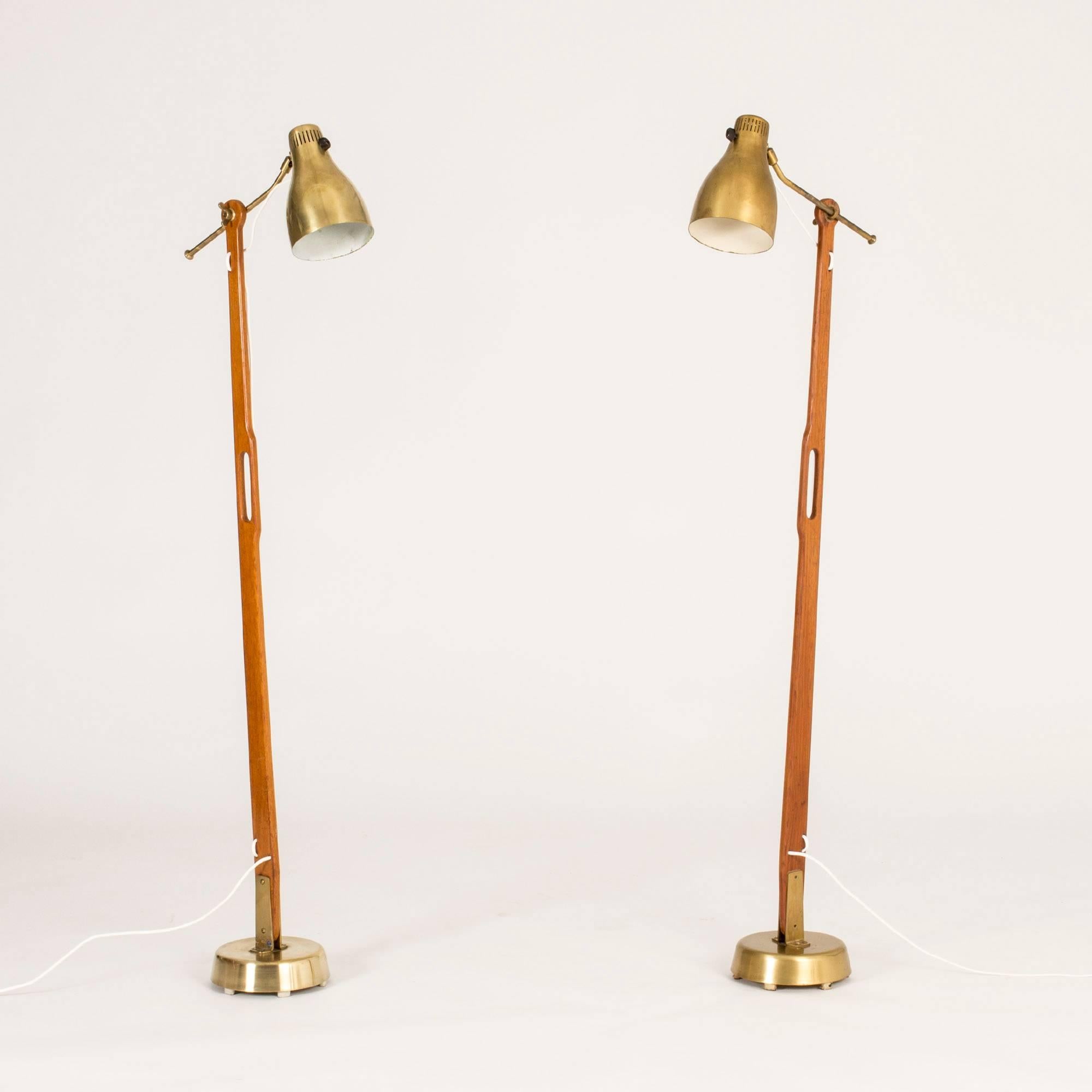 Pair of amazing teak and brass floor lamps by Hans Bergström, with wonderful attention to detail and functionality. The lamp shades can be adjusted in different angles and at different distances from the pole. Handles crafted in the teak, making the