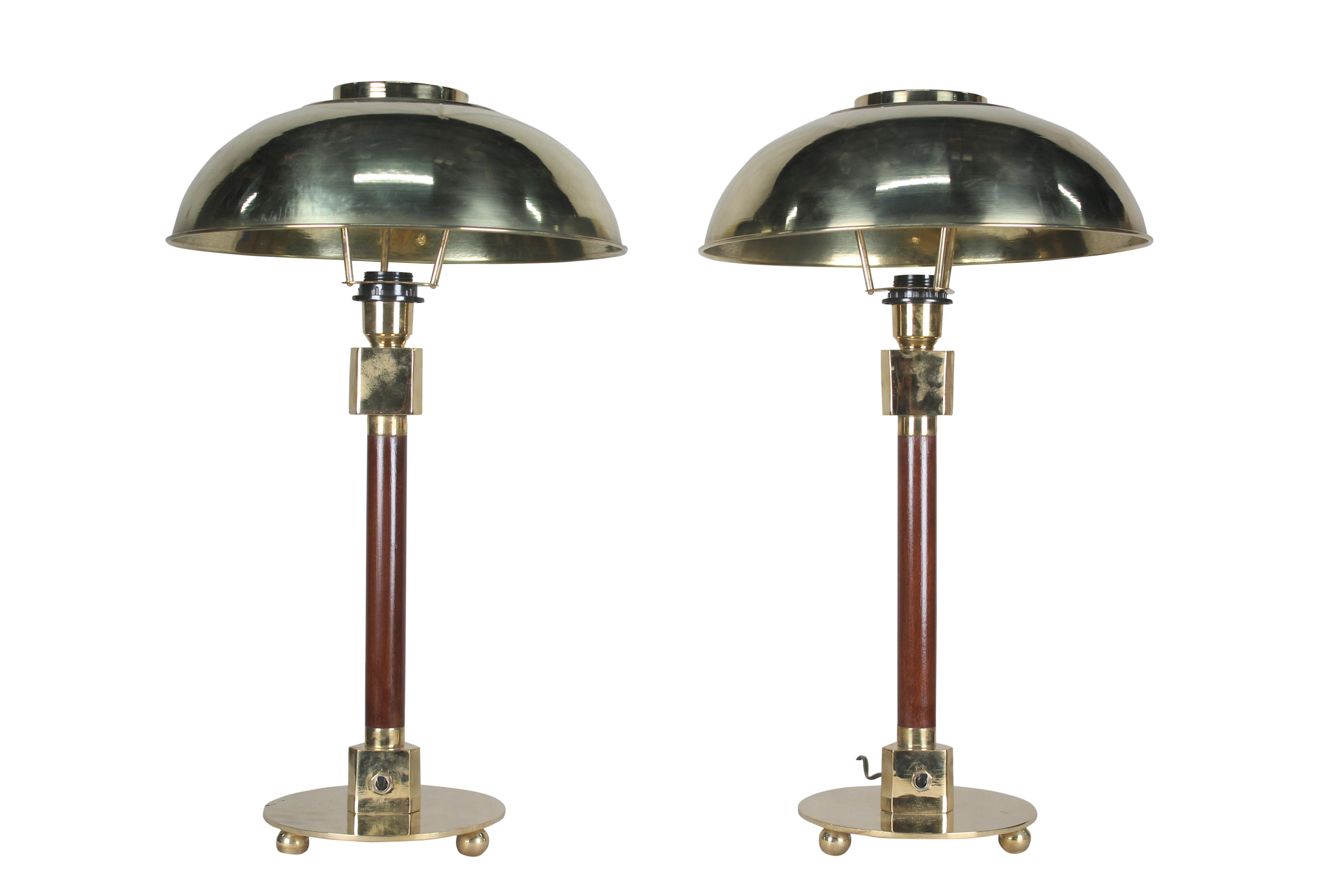Pair of teak and brass table lamps from a ship's stateroom. Domed brass shade which lifts off and lamps are rewired for American use and takes one standard base light bulb, circa 1970s. Base diameter is 8