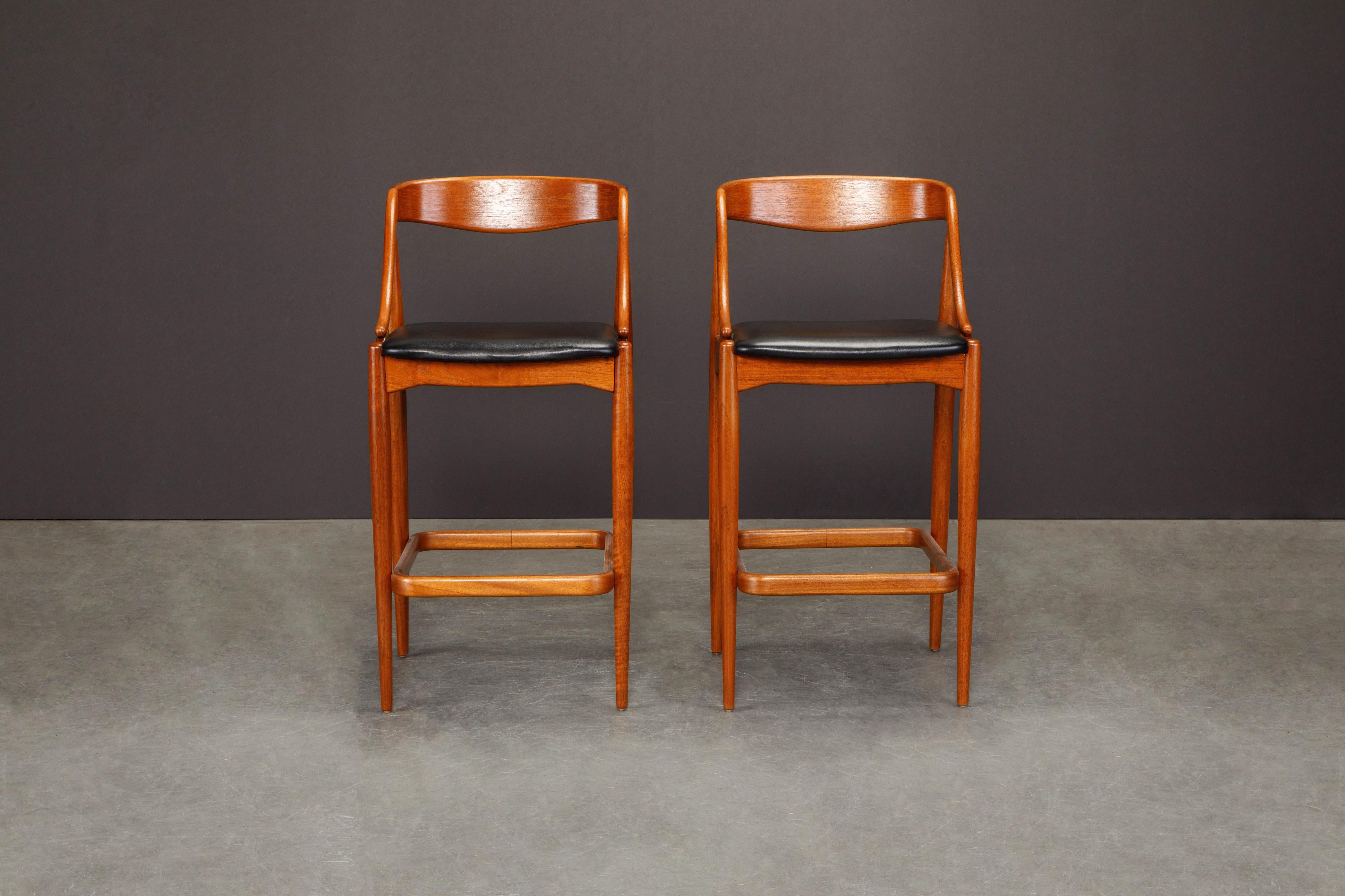 Paire de tabourets de bar modernes danois en teck et cuir noir par Johannes Andersen, vers les années 1960. Le teck a été remis à neuf, les sièges en cuir sont d'origine et présentent une belle patine. 

Ces tabourets de bar en teck des années 1960