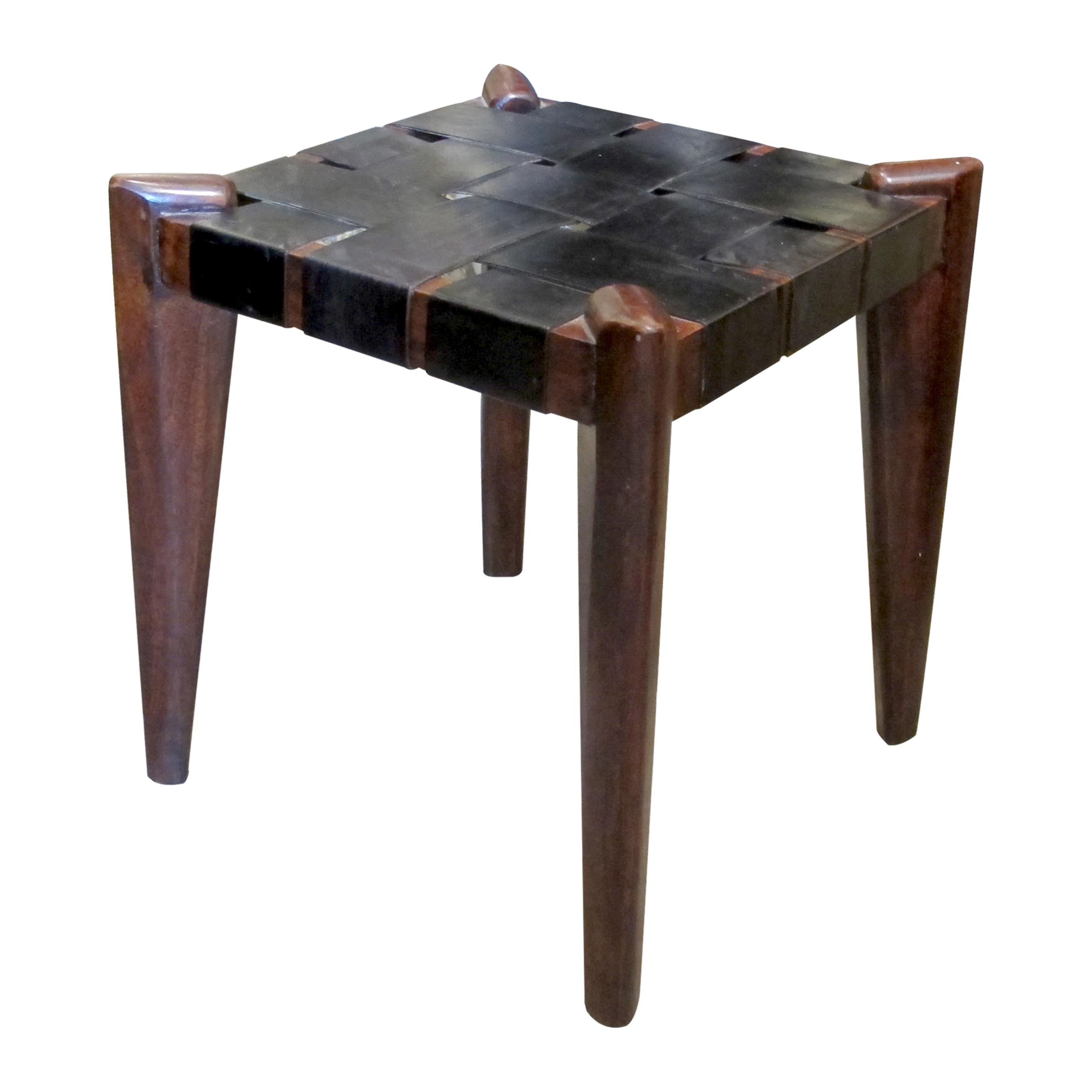 Una bella coppia di sgabelli moderni della metà del secolo scorso, caratterizzati da telai in teak massiccio scolpito con gambe affusolate e angoli distintivi curvati verso l'alto. I sedili sono realizzati con cinghie di pelle nera intrecciate, che