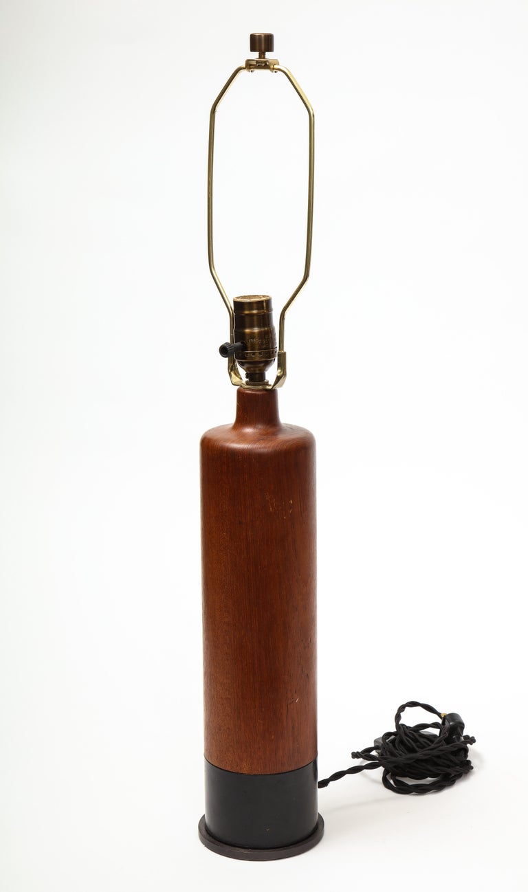 Teak and leather table lamp, Denmark, c. 1970s.

Cylindrical in shape, this lamp has been newly rewired and outfitted with a custom bronze base. 

Please Note: one table lamp available.