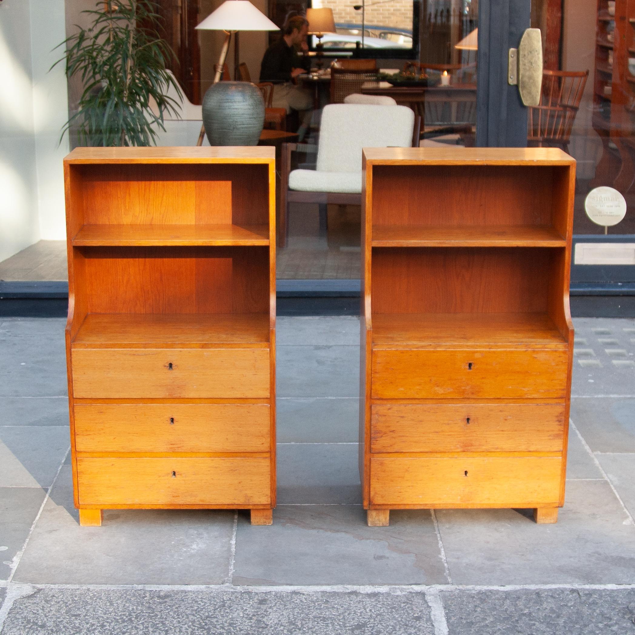 A pair of bedside cabinets by Rud. Rasmussen, Denmark, 1930s.Made of solid teak with a wonderful even patina. These cabinets rest on block feet, grounding their slender torsos created through a comfortable slope on their edges. Their forms are