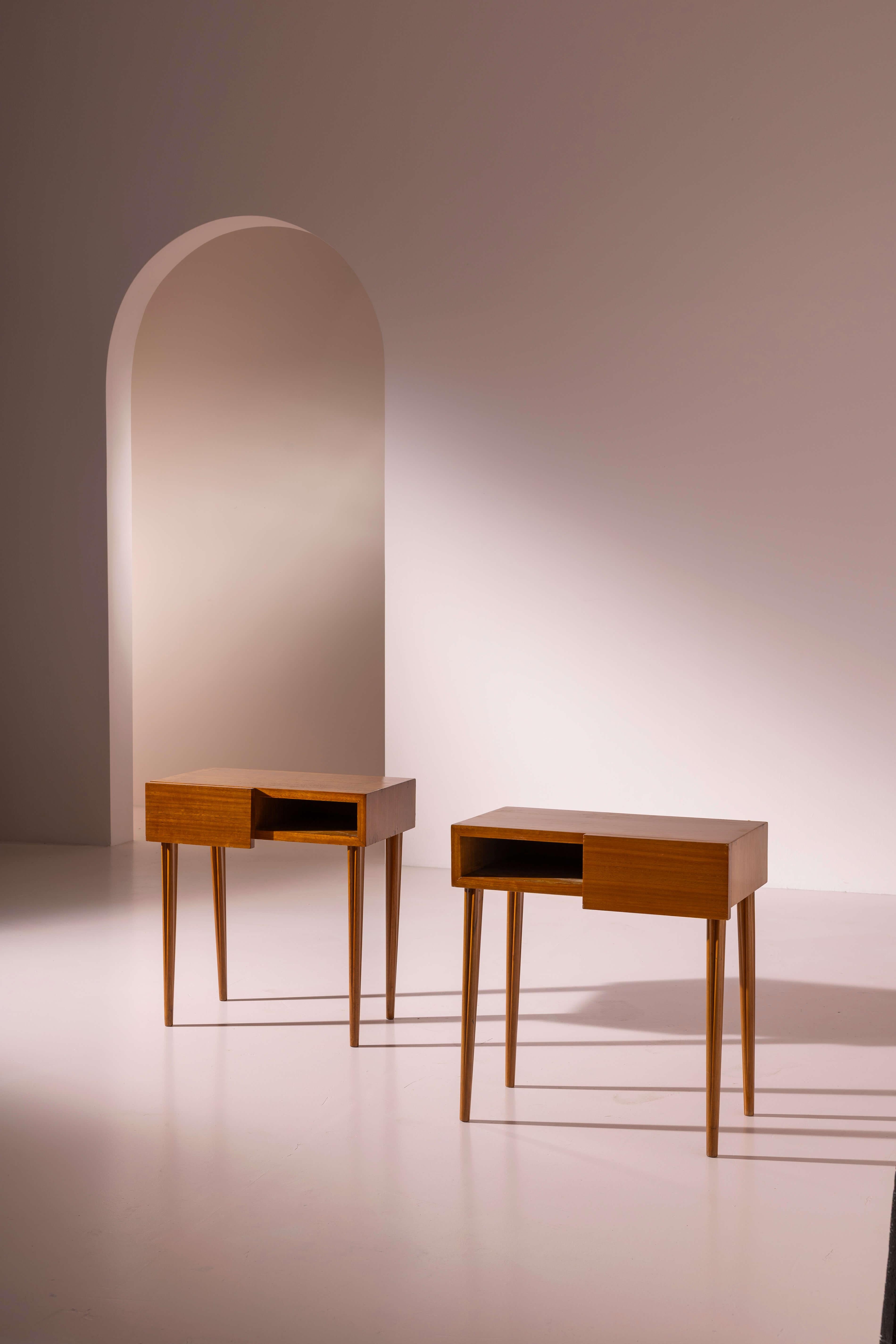 Paire de tables de chevet en teck avec tiroir sous le plateau et pieds sculptés, fabrication italienne, années 1950.

Compacte et polyvalente, cette paire de tables de chevet italiennes des années 1950 se distingue par la forme inhabituelle de ses