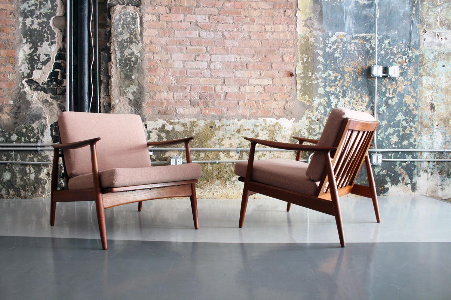 A fantastic pair of matching teak framed lounge chairs by Moreddi Denmark. Upholstered in soft pink colored bucle fabric.