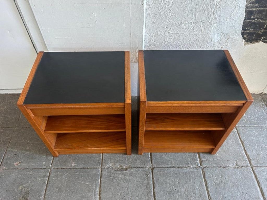 Coppia di comodini moderni danesi in teak con cassetto singolo e ripiano regolabile. Comodini o tavolini danesi dallo stile semplice e a blocchi. I piani sono laccati neri su teak. Ogni comodino ha un unico cassetto con un unico ripiano inferiore