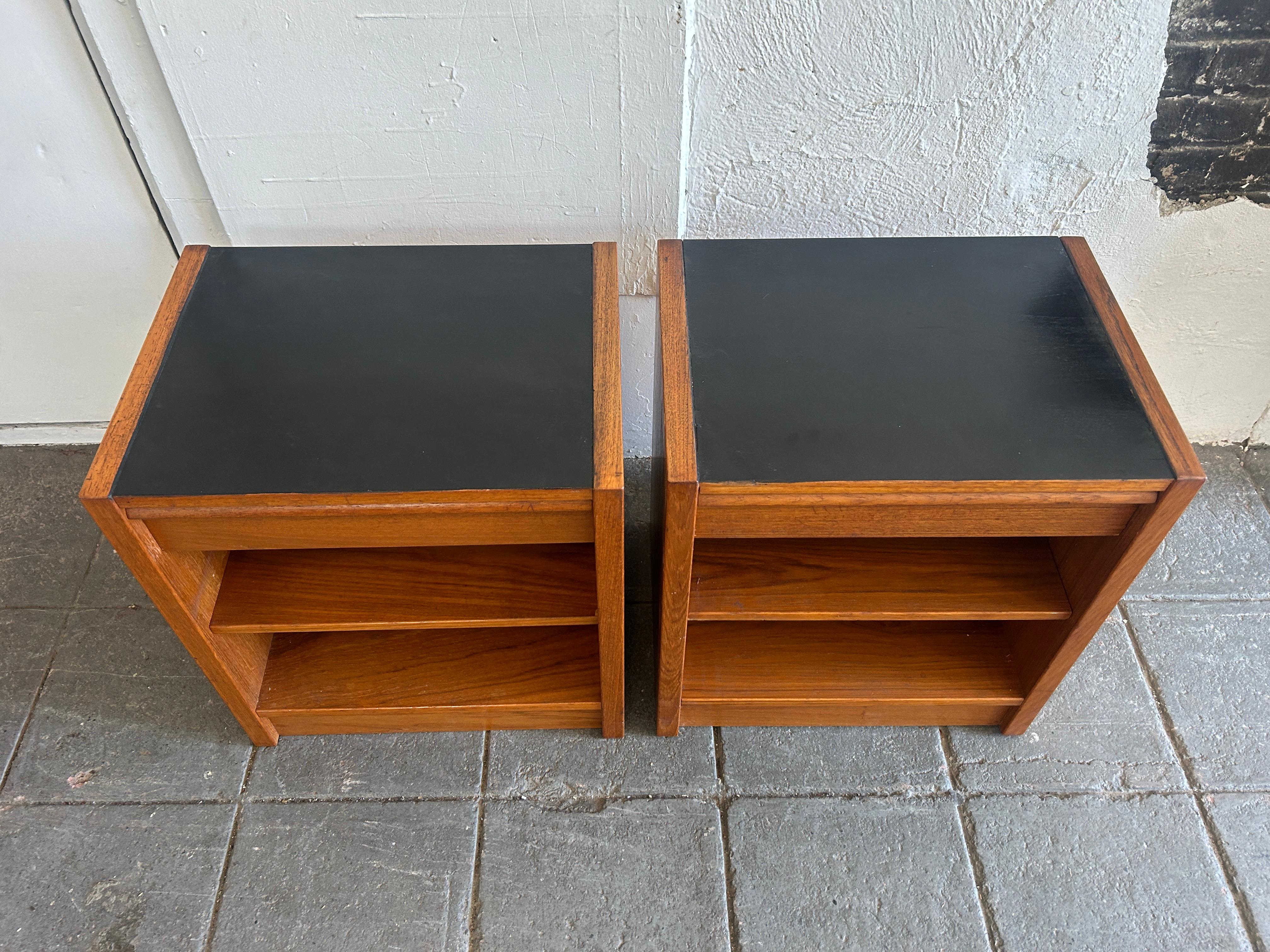 Pair of teak danish modern nightstands with single drawer and adjustable shelf. Great simple block style Danish nightstands or end tables. Tops are black lacquer on teak. Each nightstand has a single drawer with a single lower shelf that is