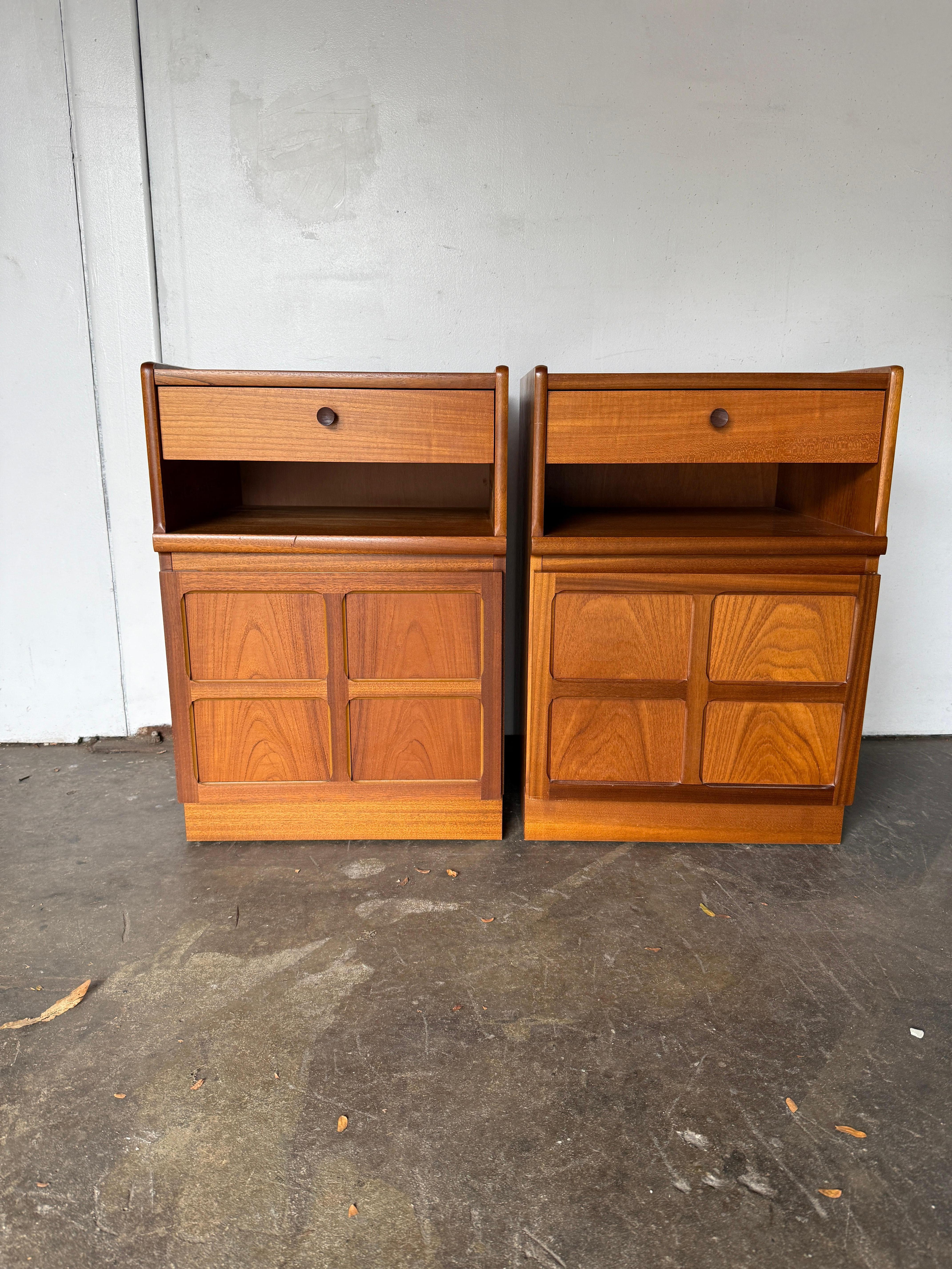 Pair of teak danish modern single drawer with lower cabinet nightstands. Very clean set of Danish Modern Nightstands. Sold as a Pair (2) Nightstands. Has (1) Upper single drawer that has a wooden knob and a lower open cabinet. Made in Denmark.
