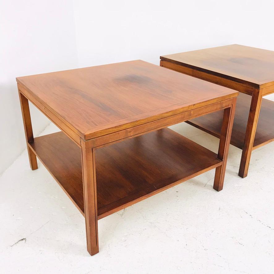 Handsome pair of teak wood mid-century 2-tier side tables. Beautiful finish and timeless shape. Good vintage condition.