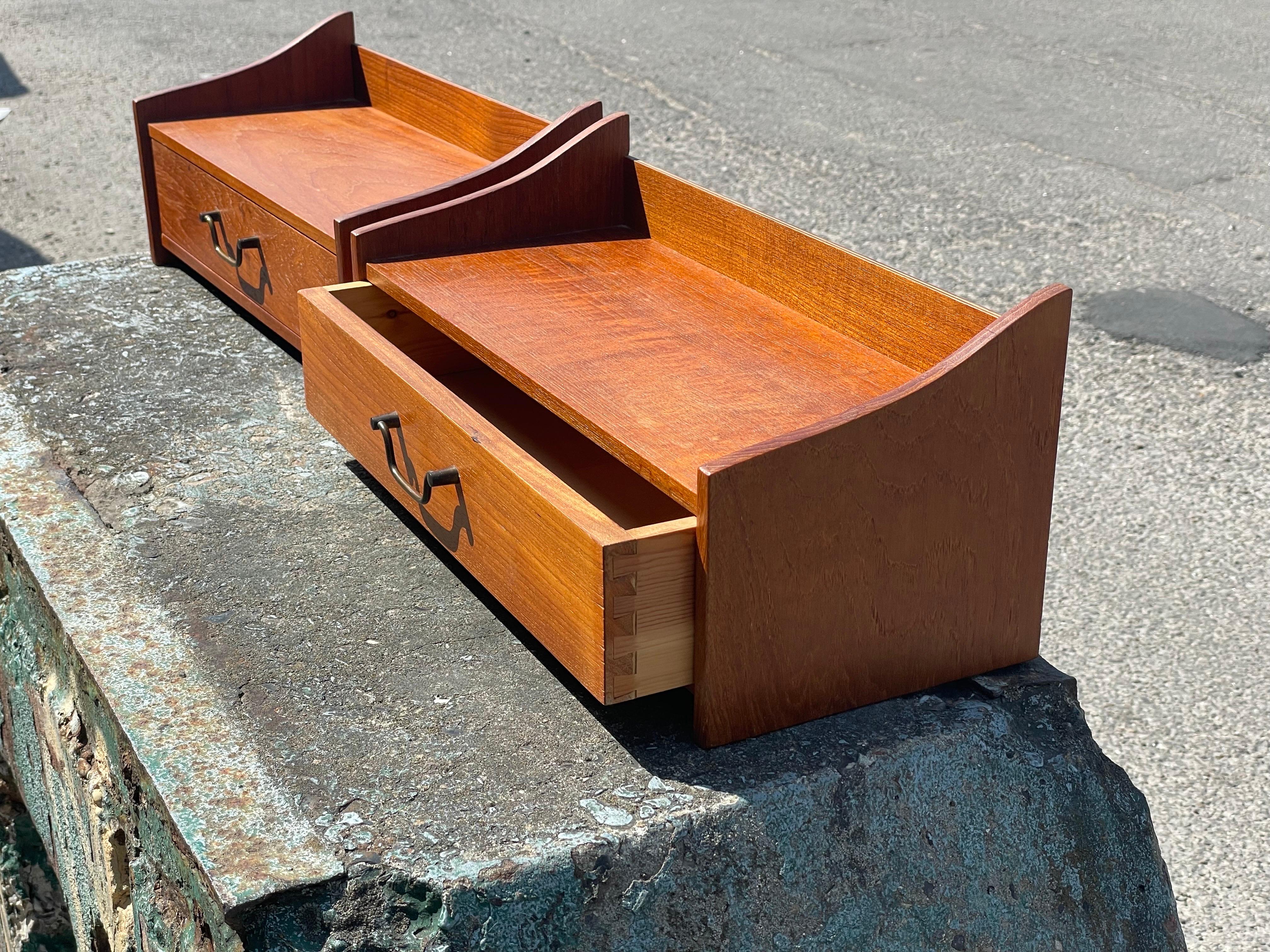 A vintage Danish set of Teak Floating shelves from the 1960s. These mid-century modern wall mounted bedside tables/nightstands/wall consoles are a true testament to Danish craftsmanship. With a single drawer adorned with a solid brass pull, they