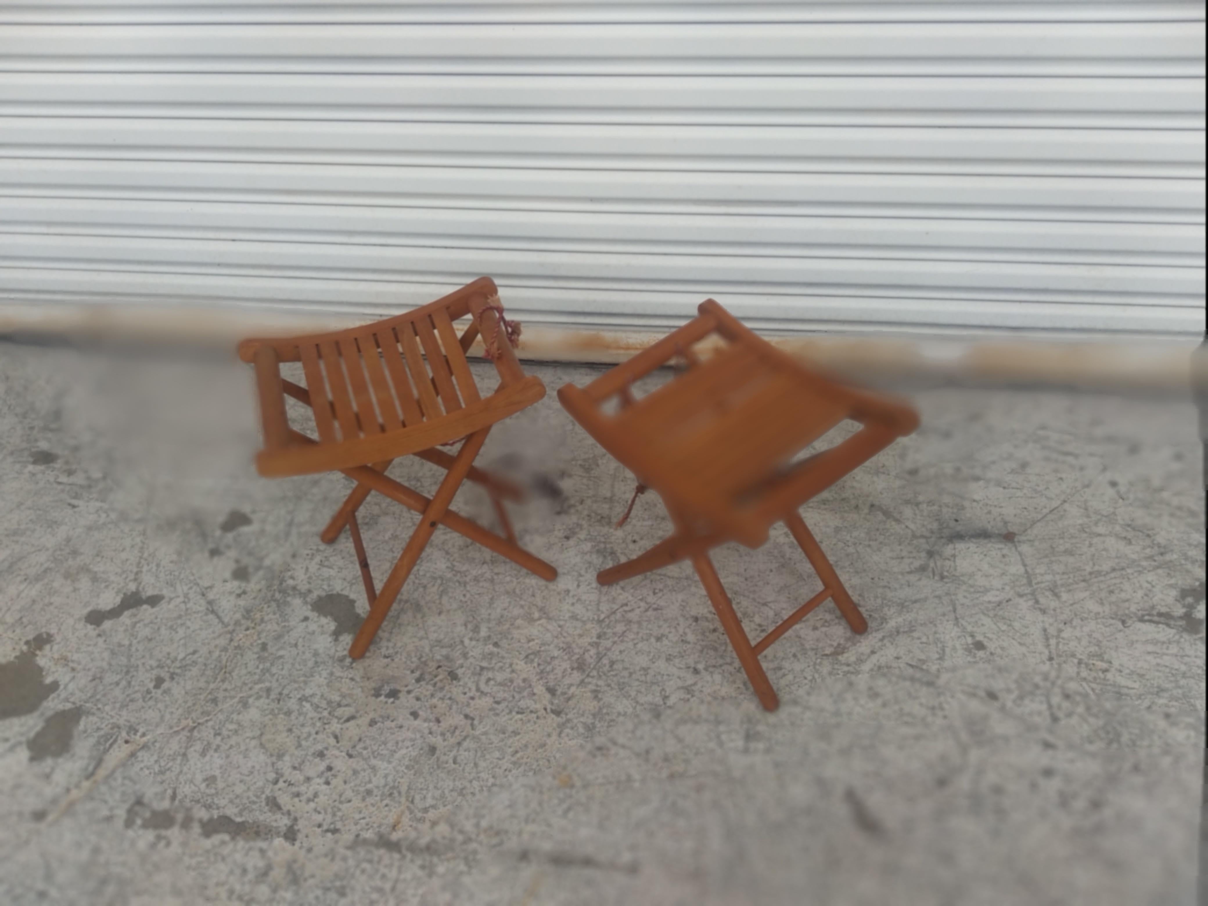 These stools fold up for great portability. They're made of teak and come from Yugoslavia. They're made by Nevco. The seats are slotted..